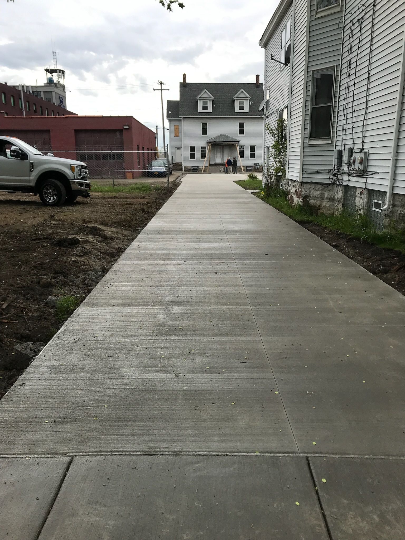 A concrete walkway leading to a white house