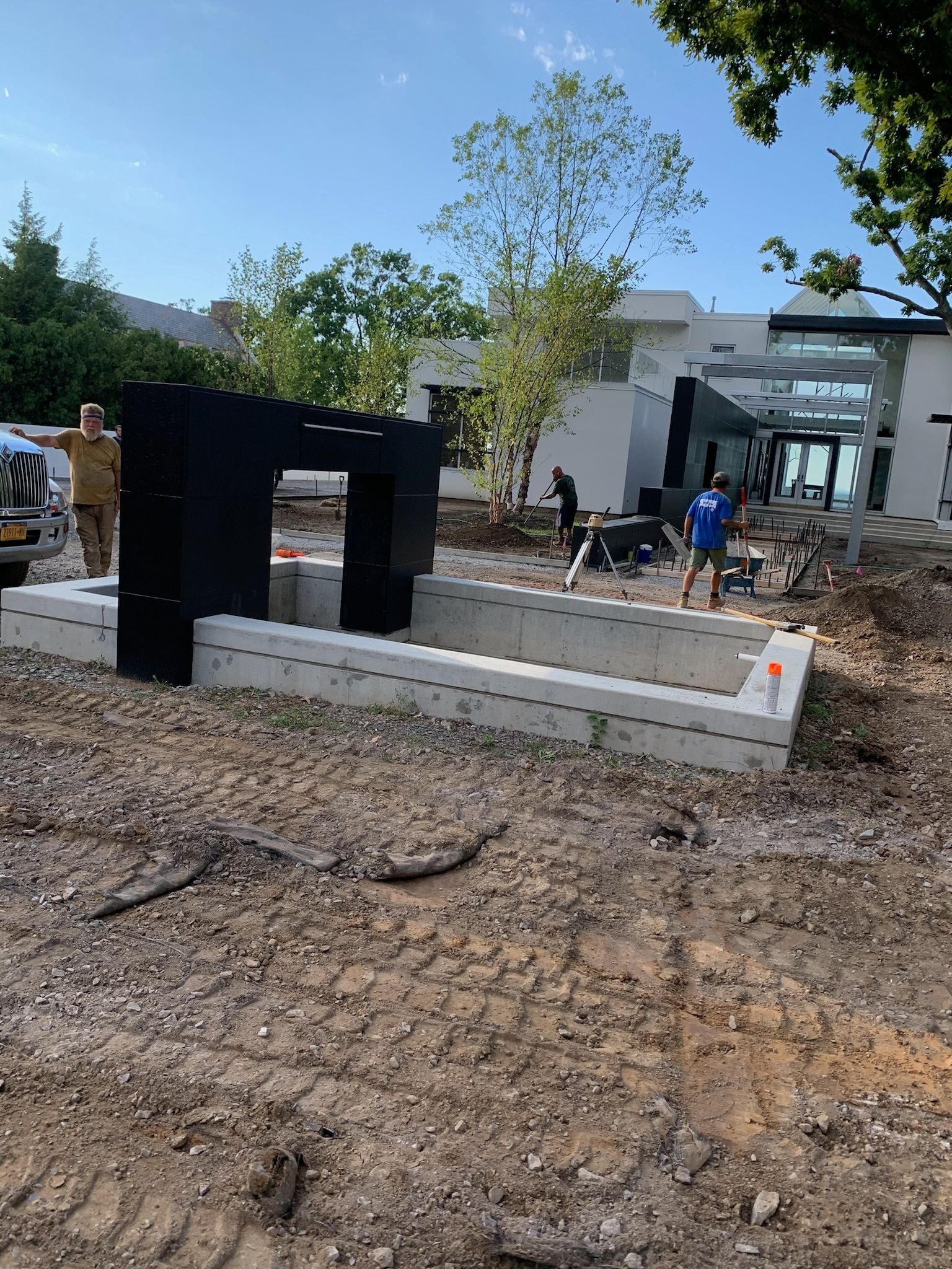 A group of people are working on a construction site in front of a house.