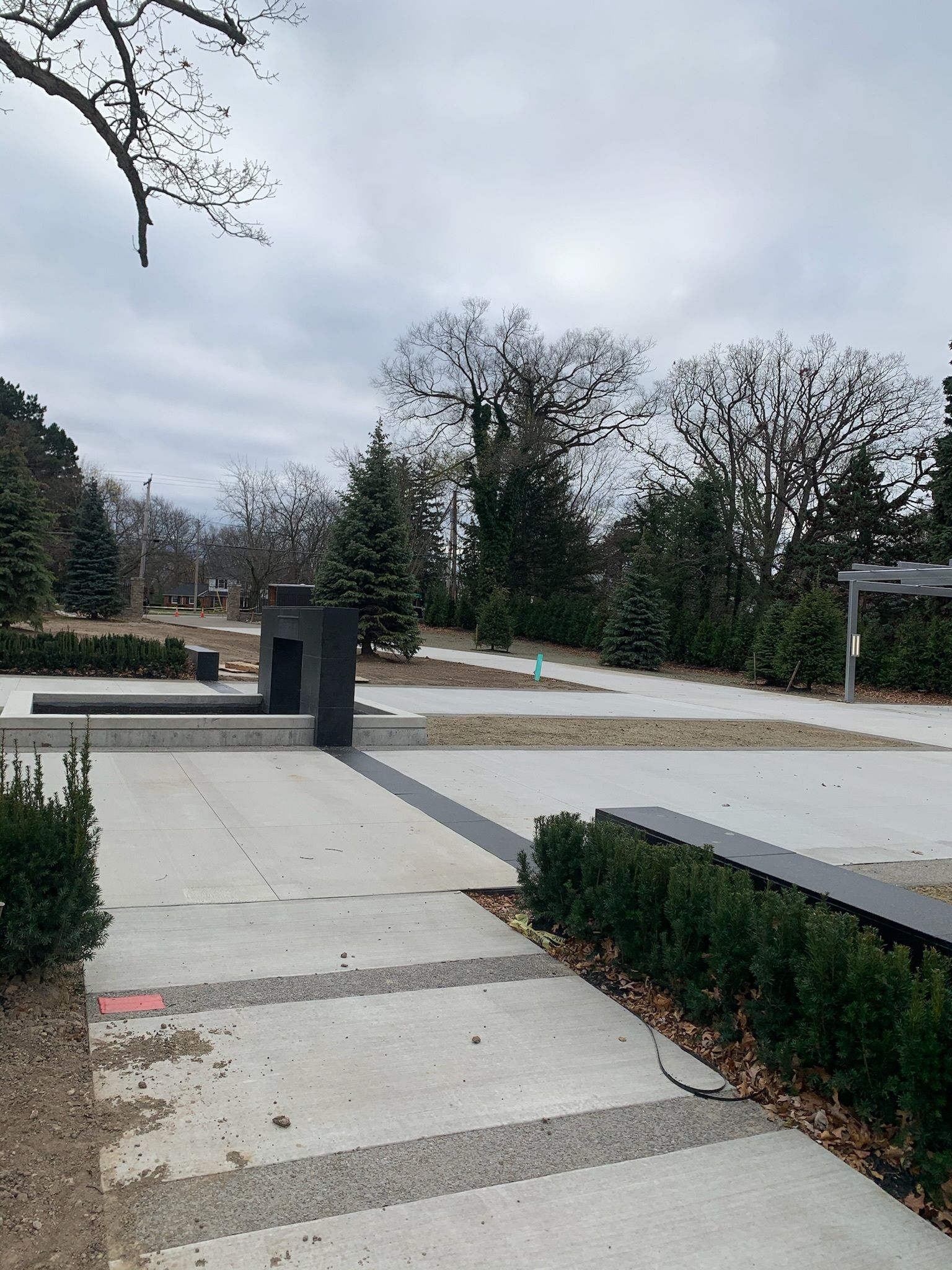 A concrete walkway in a park with trees in the background