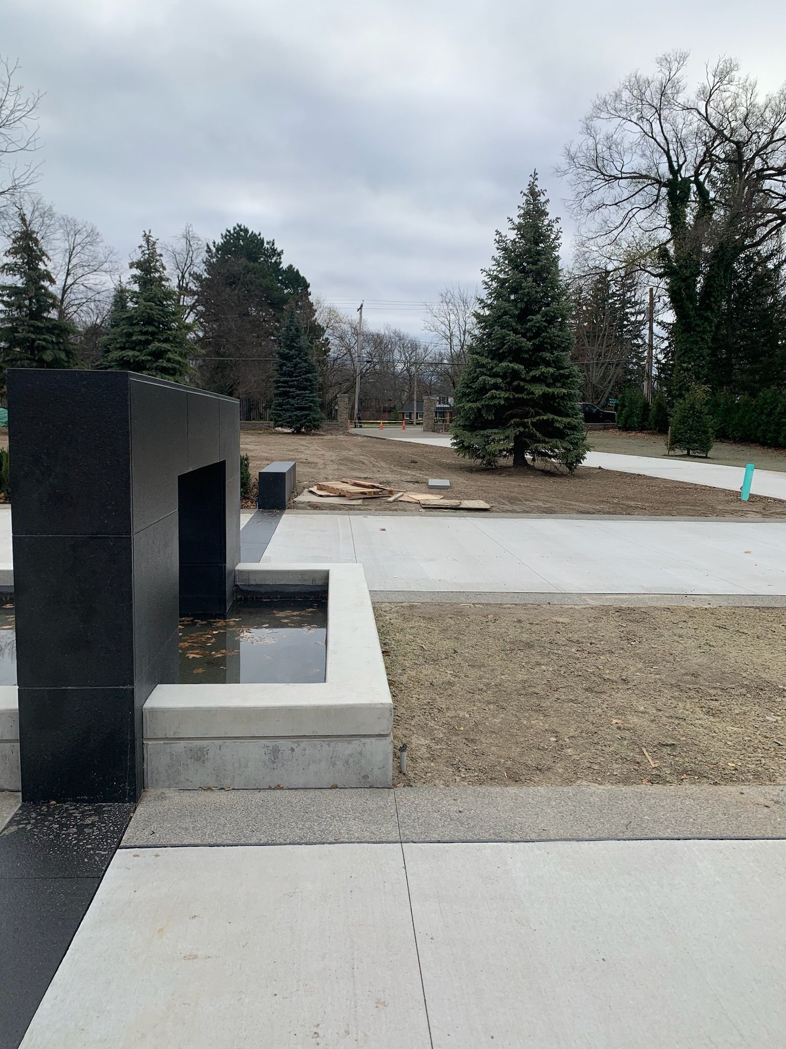 A fountain in a park with trees in the background