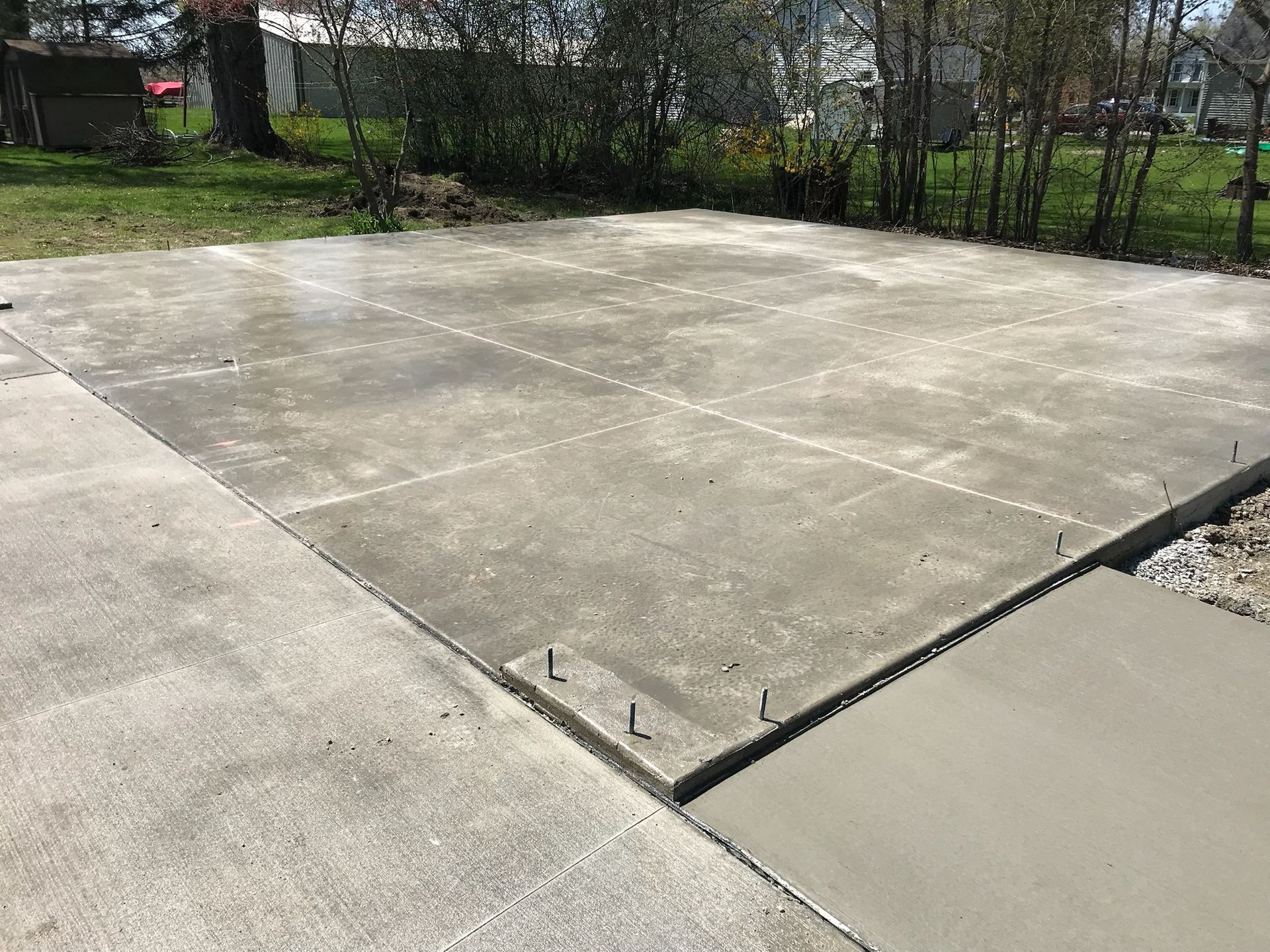 A concrete driveway is being built in a backyard.