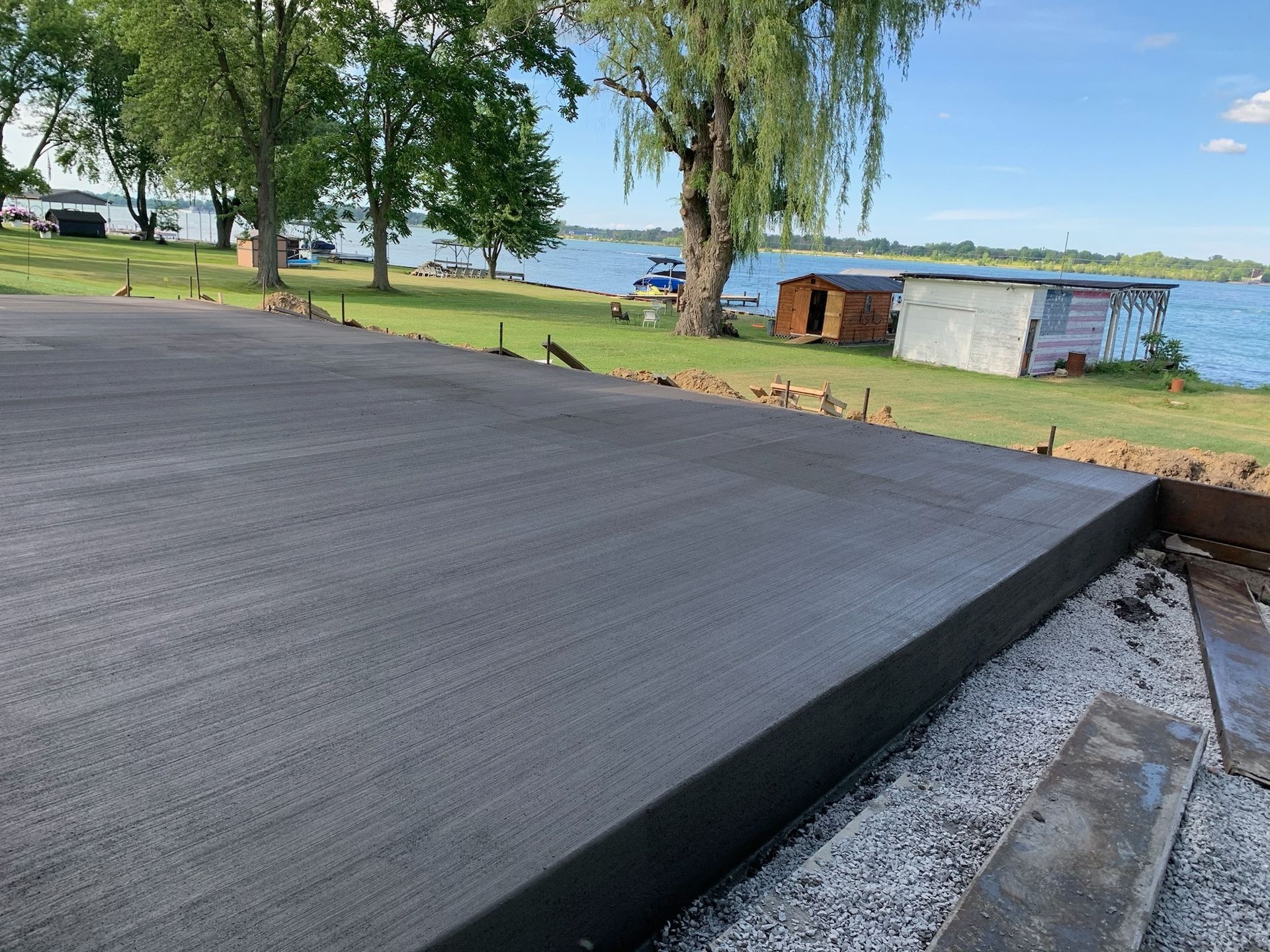 A concrete driveway is being built next to a lake.