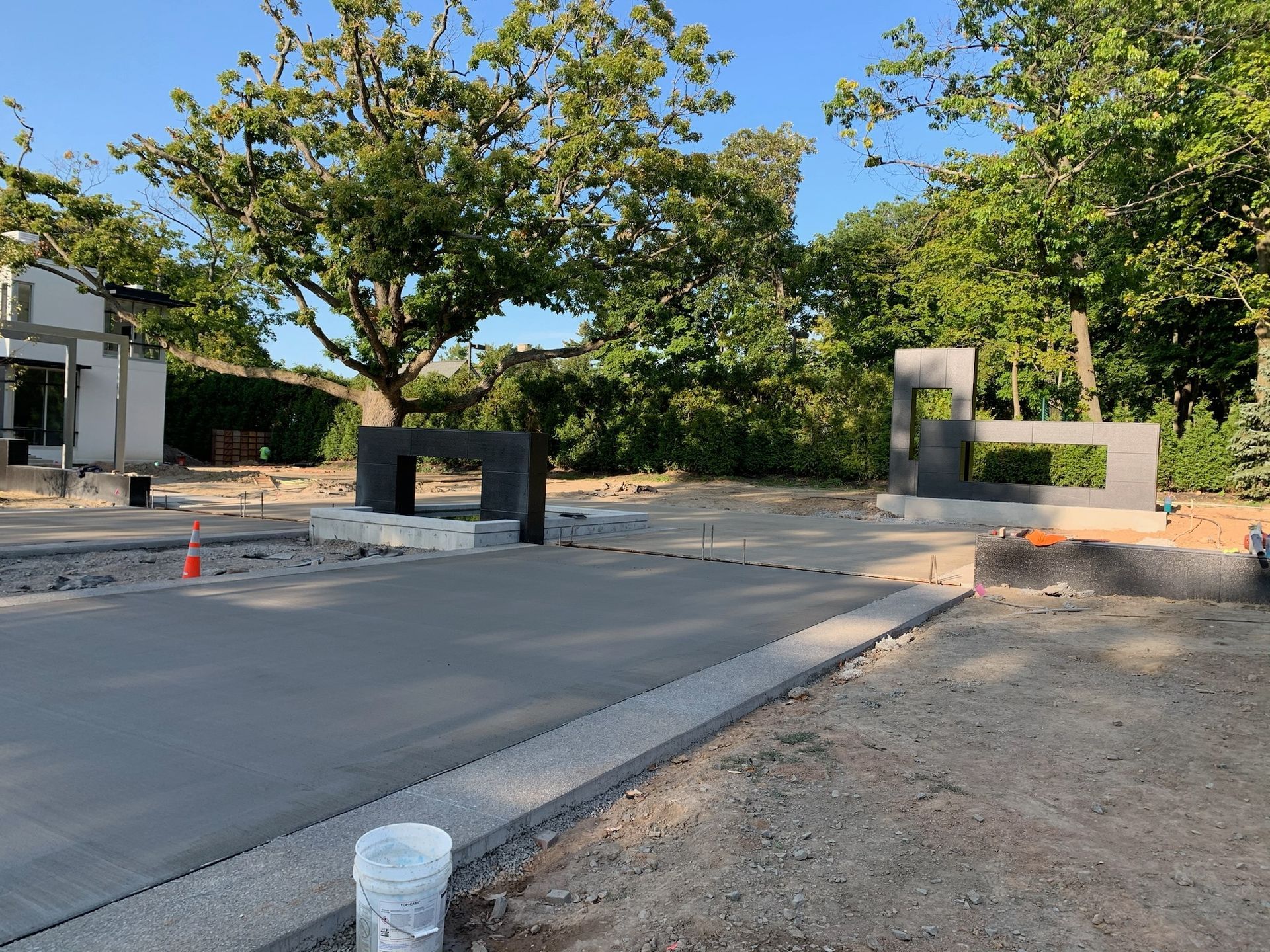 A bucket of water is sitting on the side of the road in front of a building under construction.