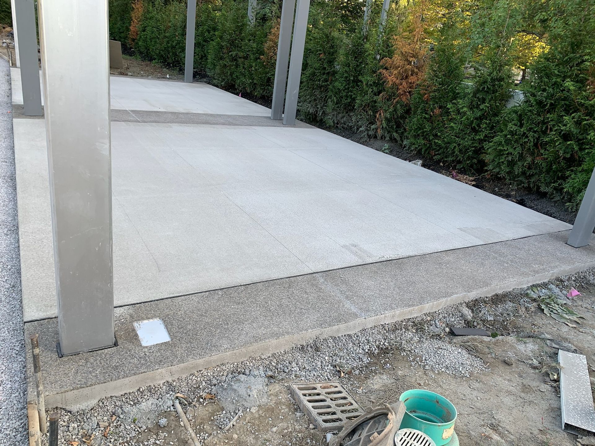 A concrete walkway is being built next to a fence.