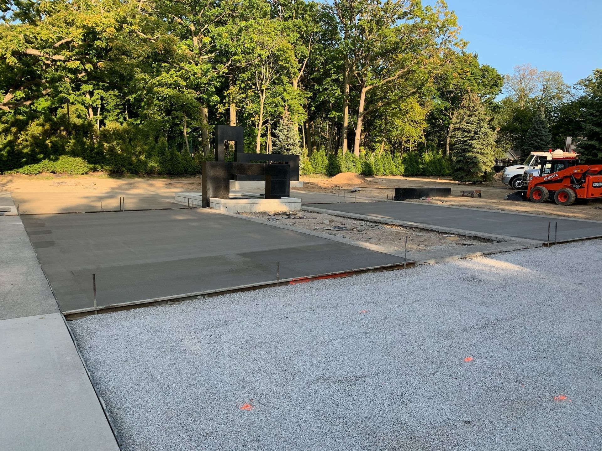 A construction site with a lot of gravel and trees in the background.