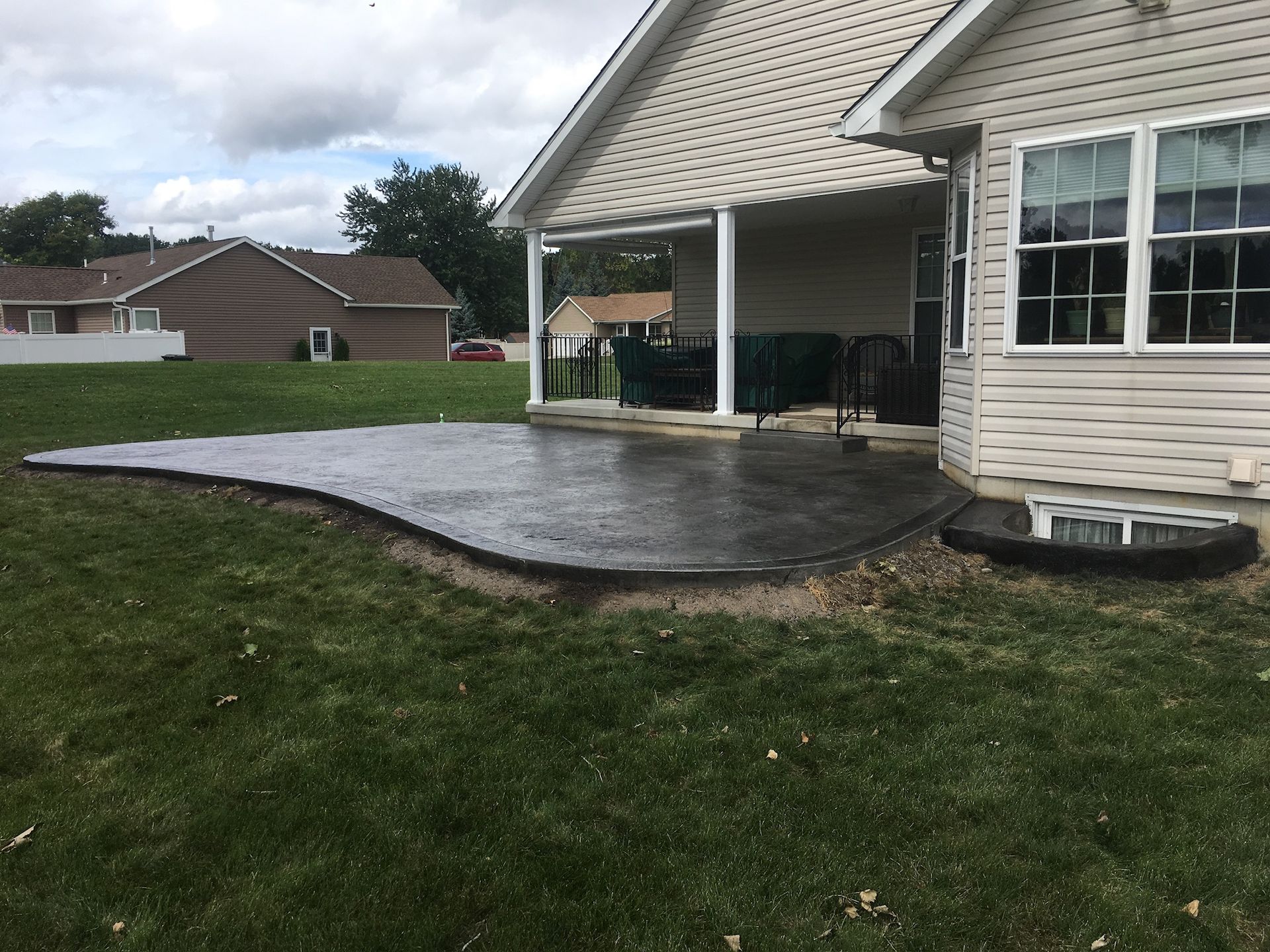 A house with a concrete patio in front of it.