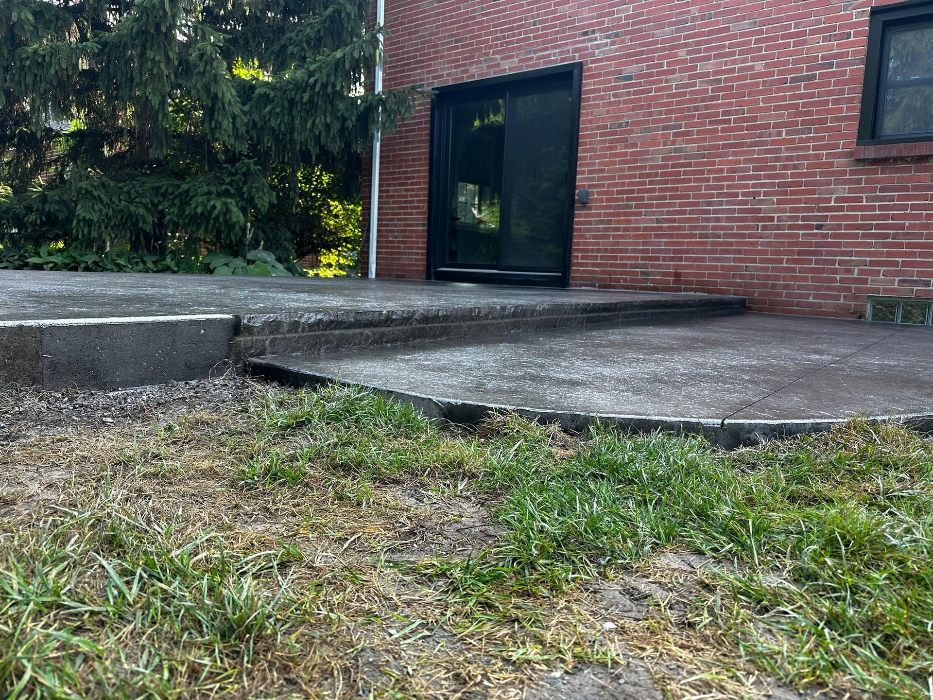 A brick building with a concrete patio in front of it.