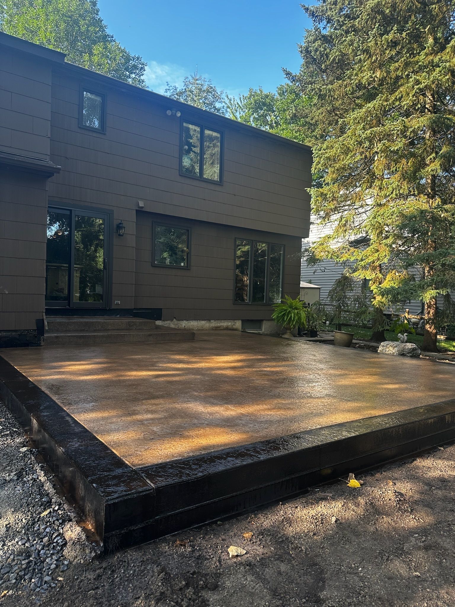 A large house with a concrete patio in front of it.