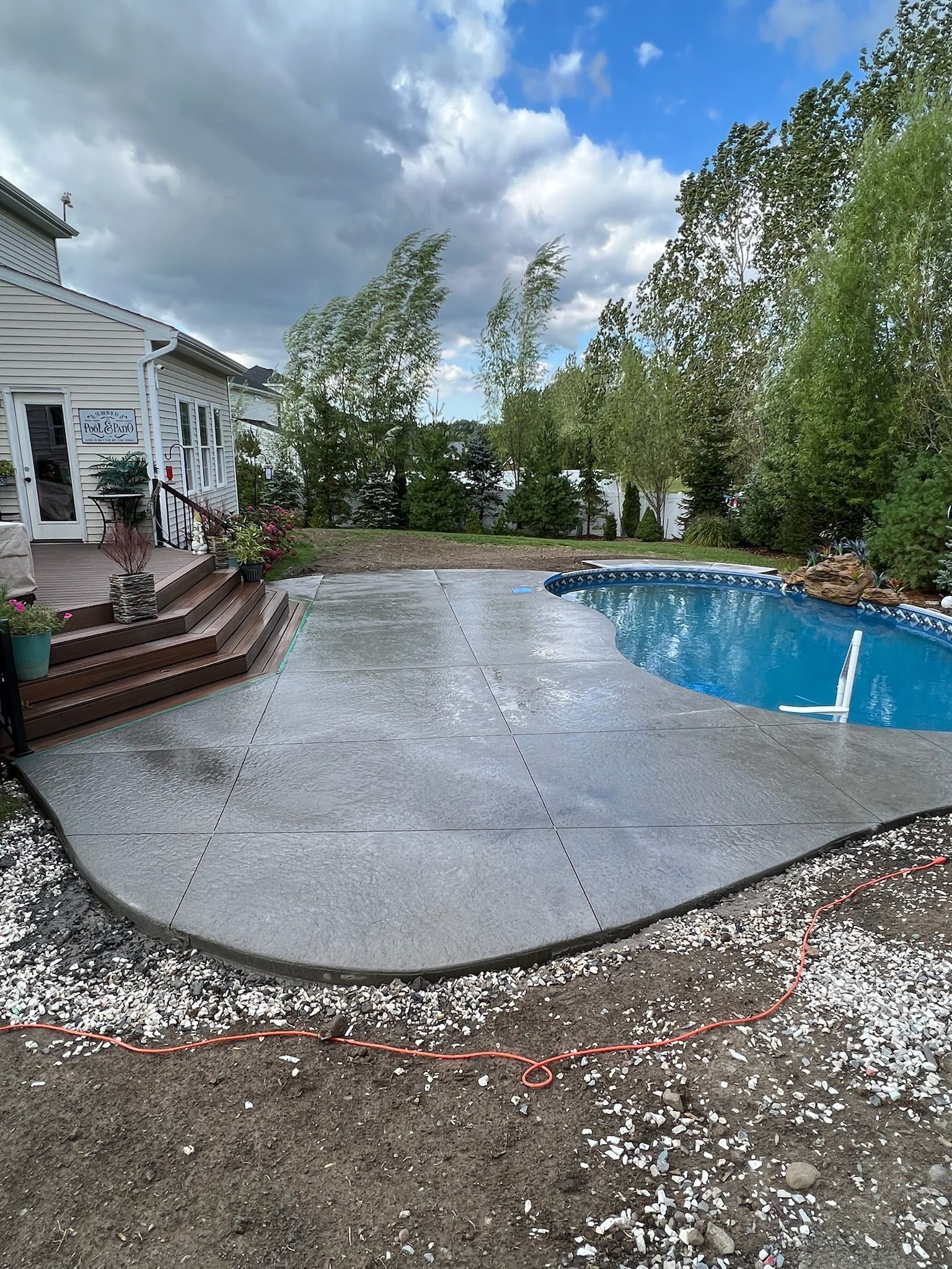 There is a large swimming pool in the backyard of a house.