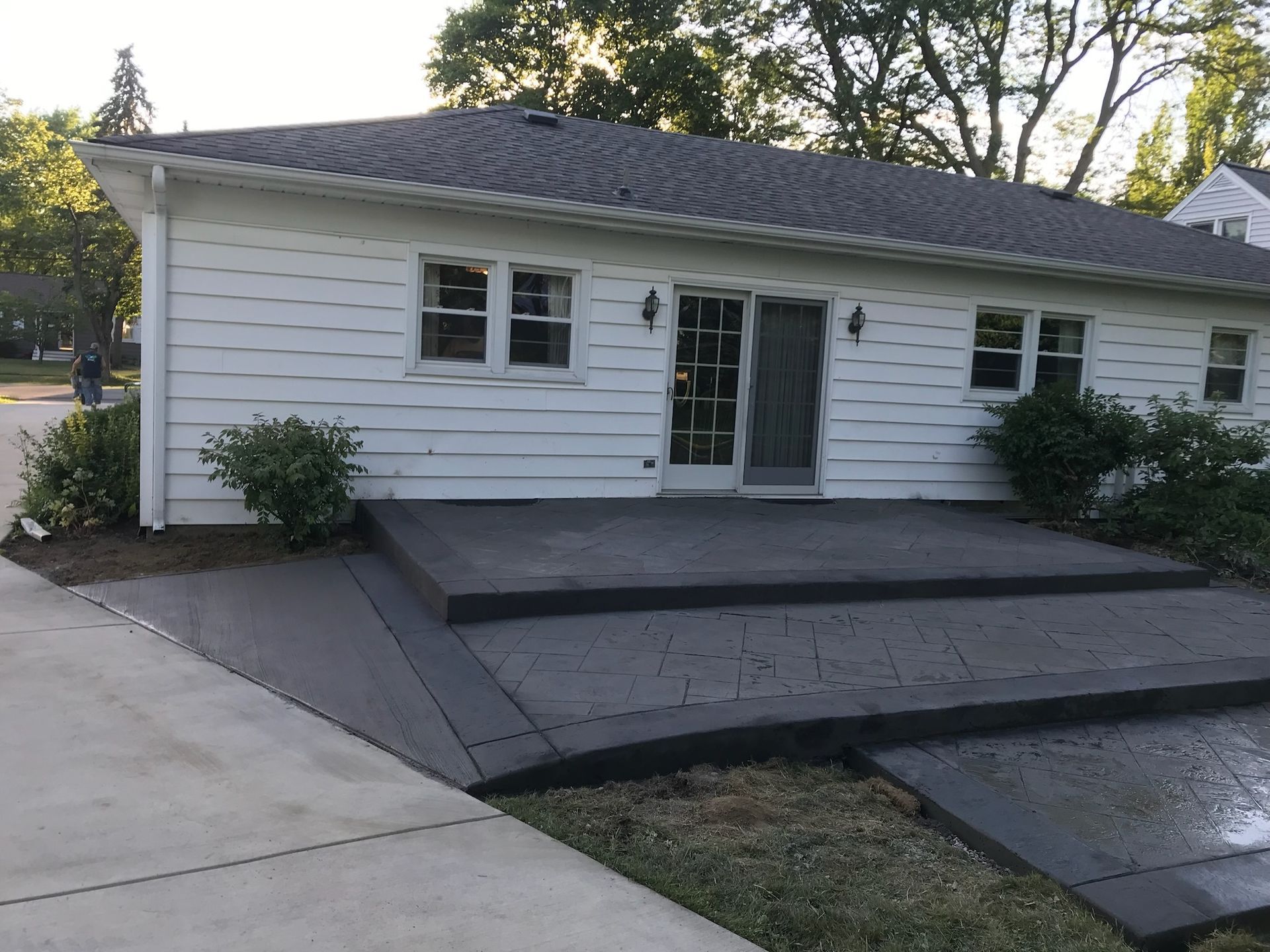 A white house with a concrete patio in front of it.