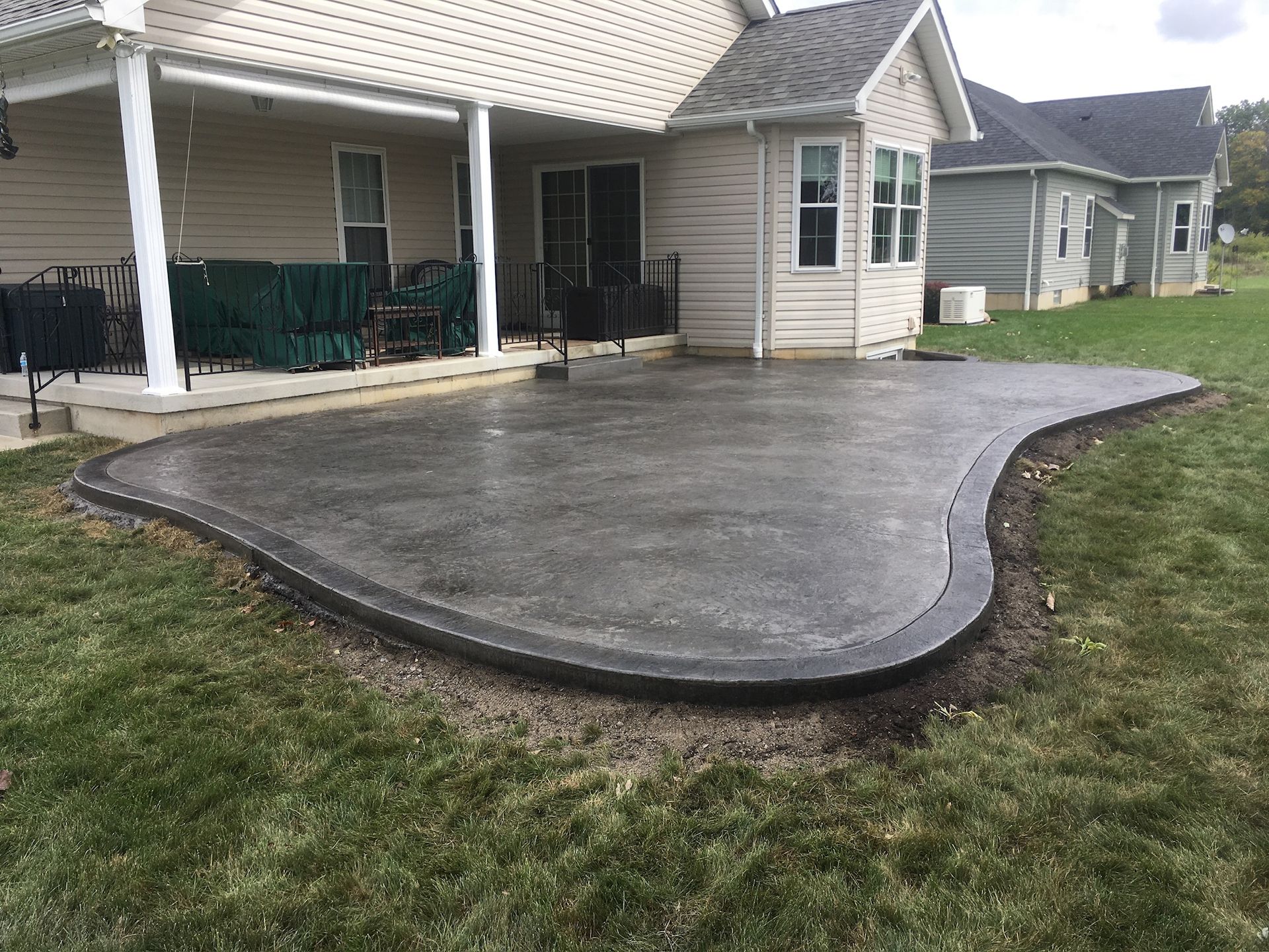 A concrete patio is being built in front of a house.