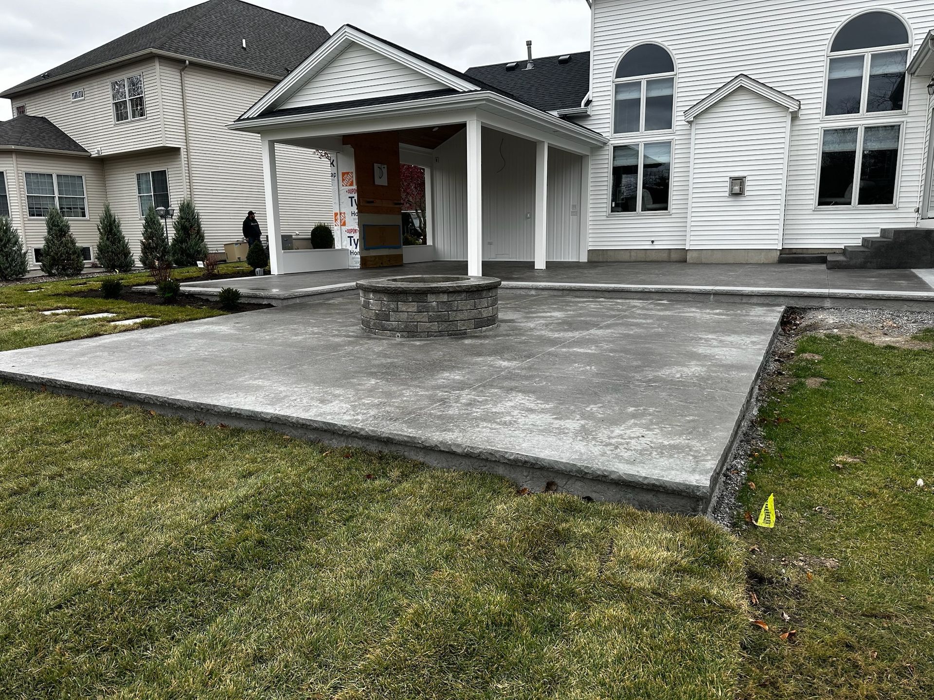A large white house with a concrete patio in front of it.