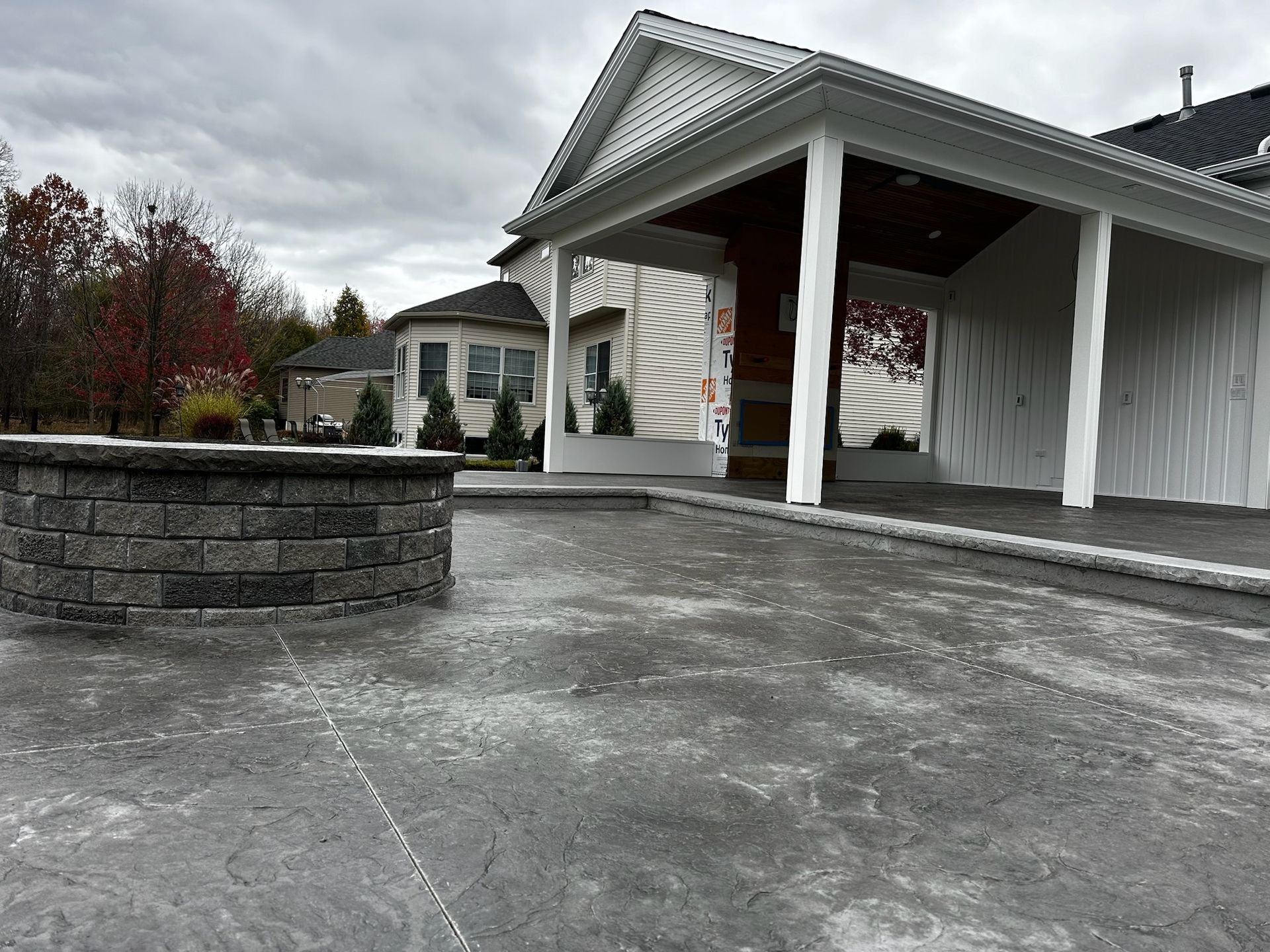 A house with a porch and a concrete driveway in front of it.