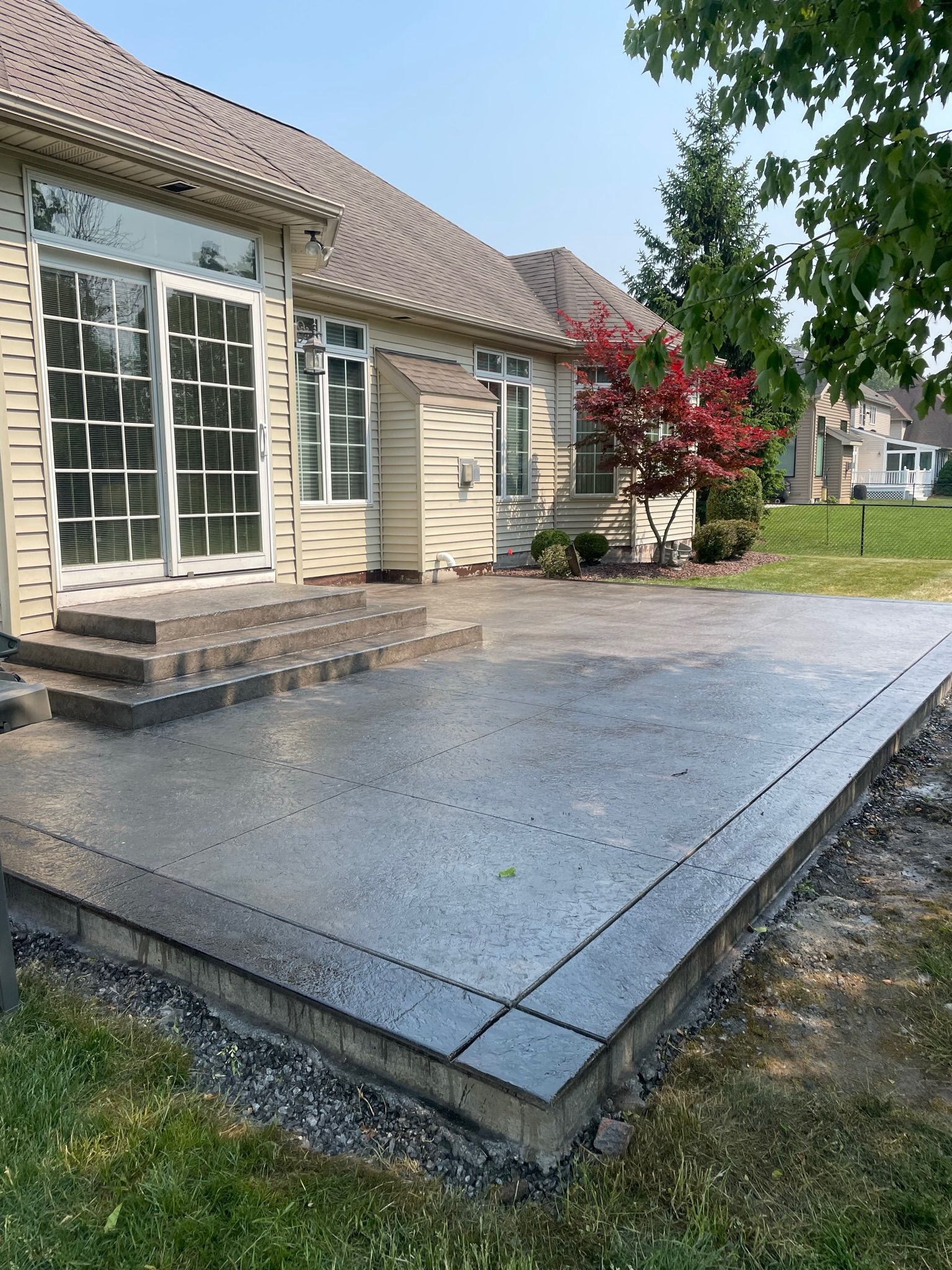 A house with a concrete patio in front of it.