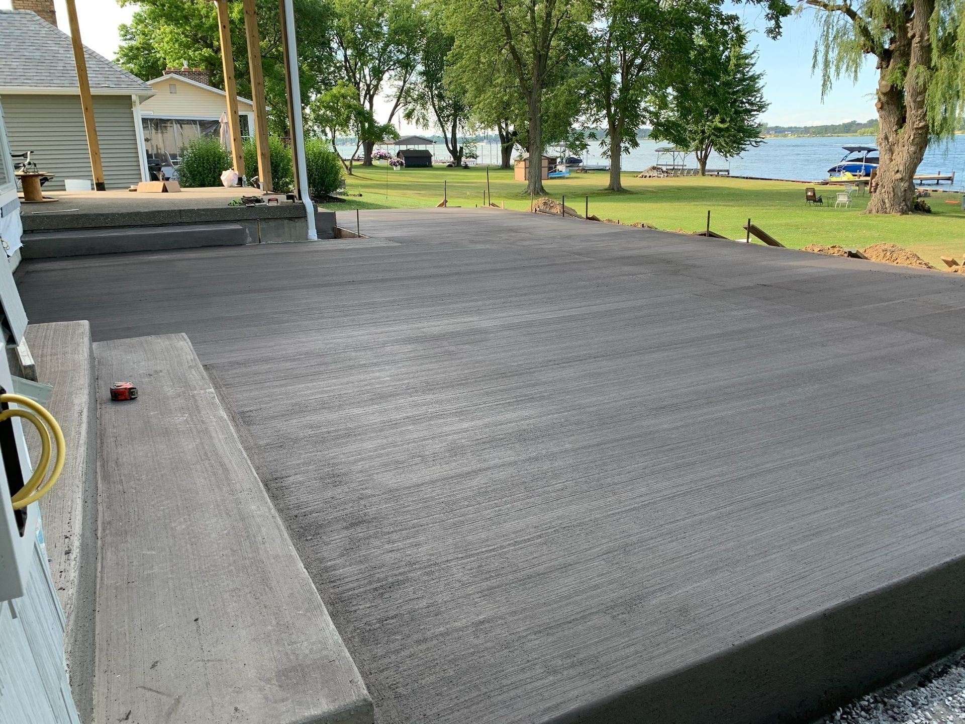 A concrete driveway is being built next to a lake.