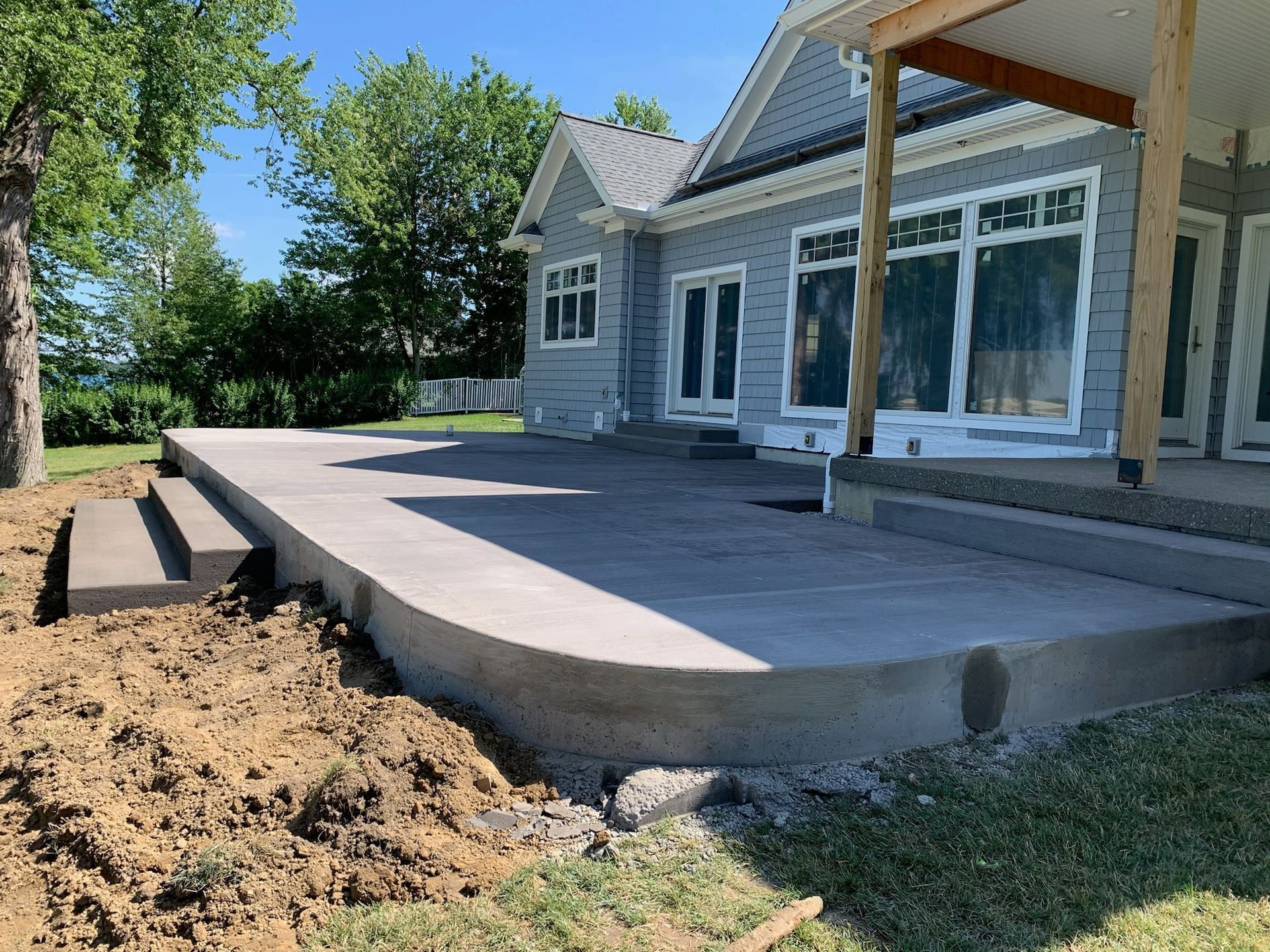 A concrete patio is being built in front of a house.