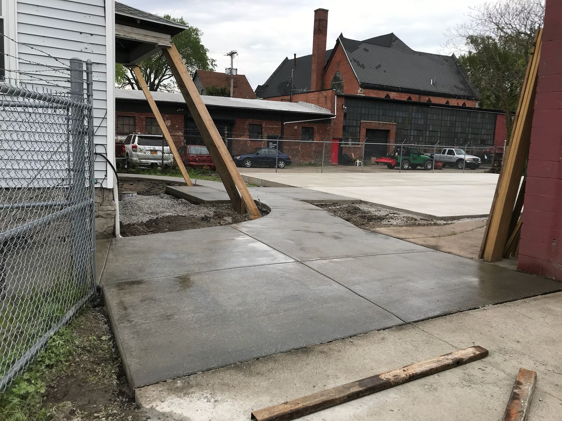 A concrete walkway is being built in front of a brick building.