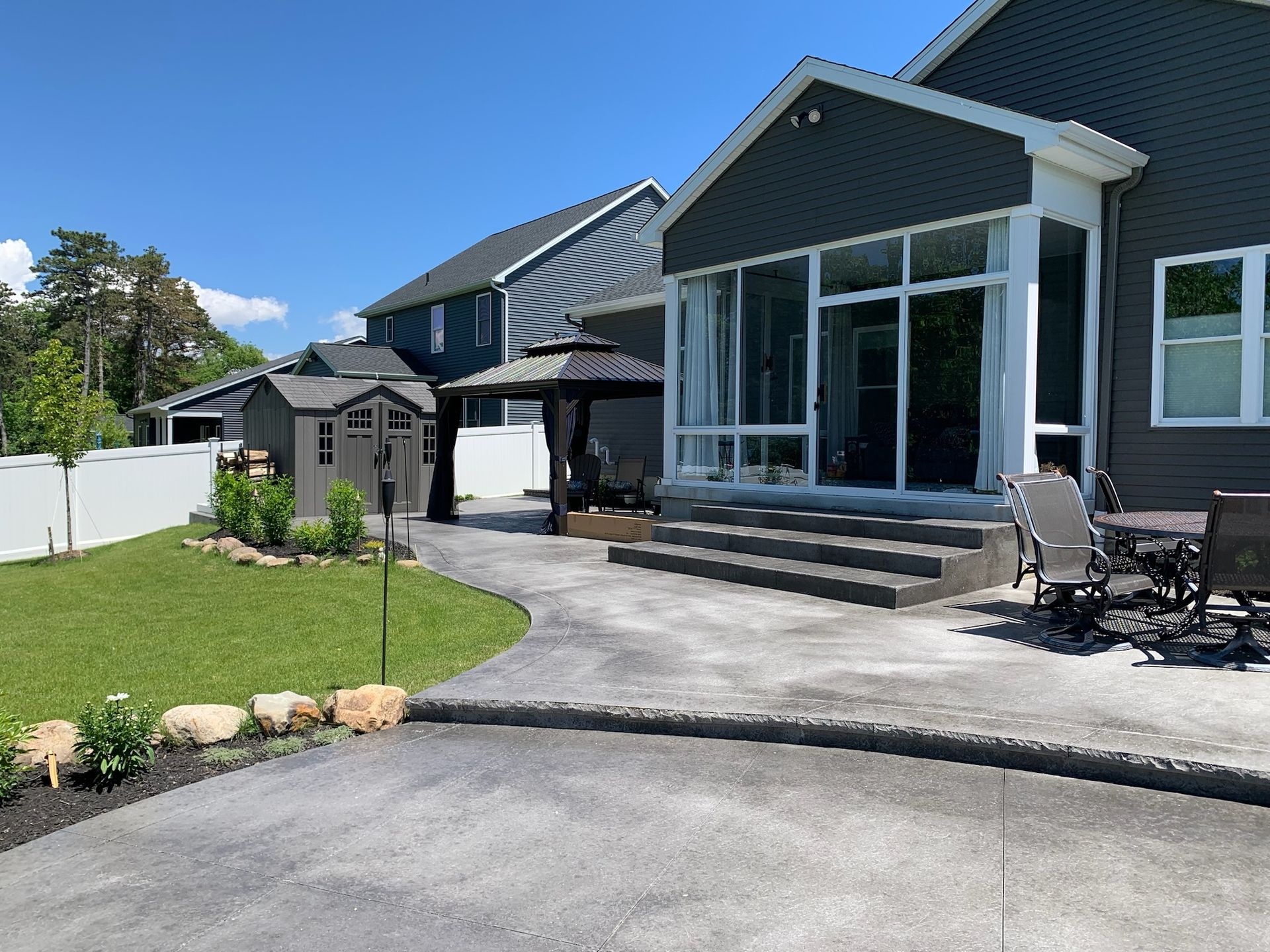 The backyard of a house with a patio and a gazebo.