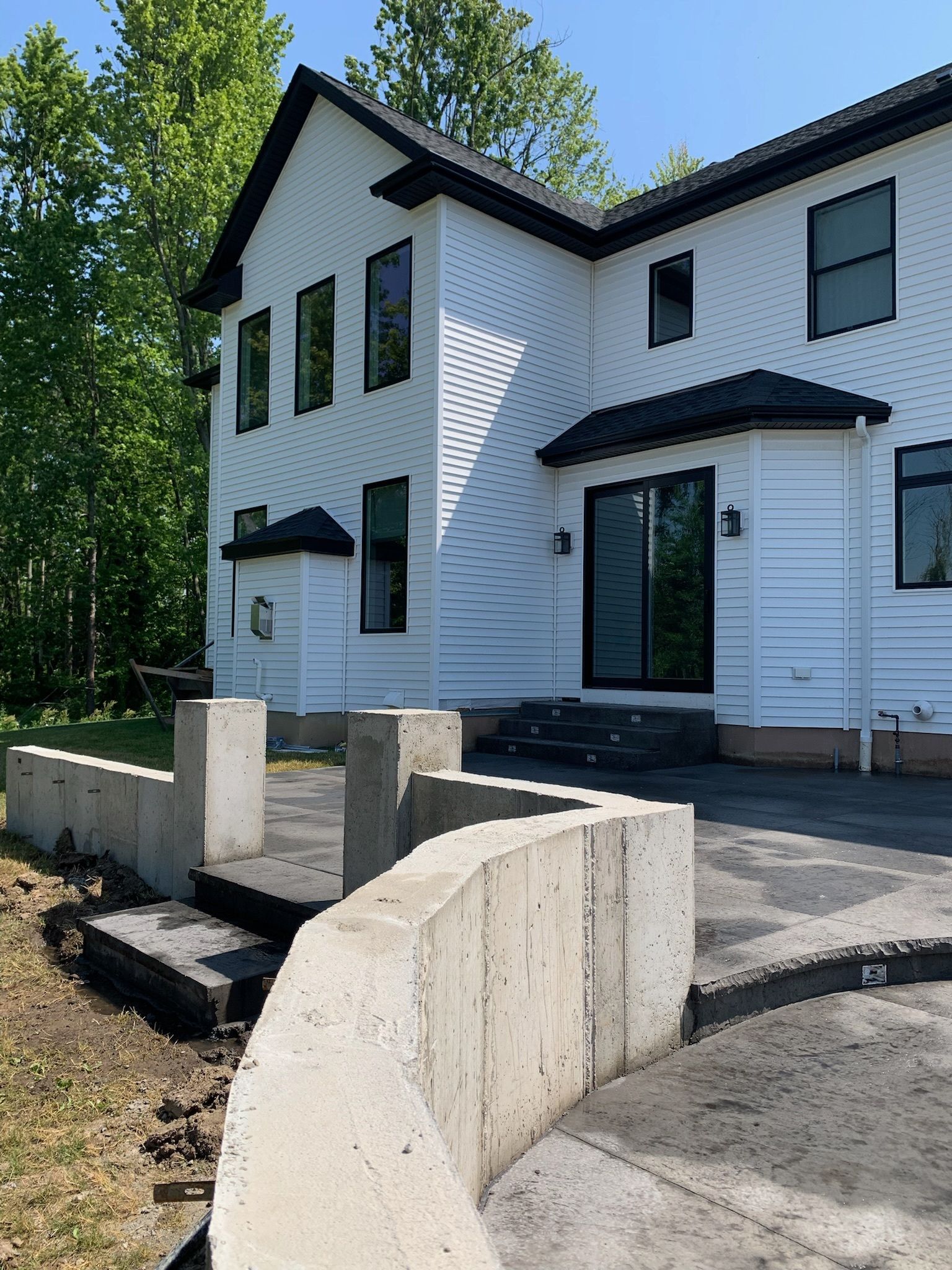 A large white house with a concrete walkway in front of it.