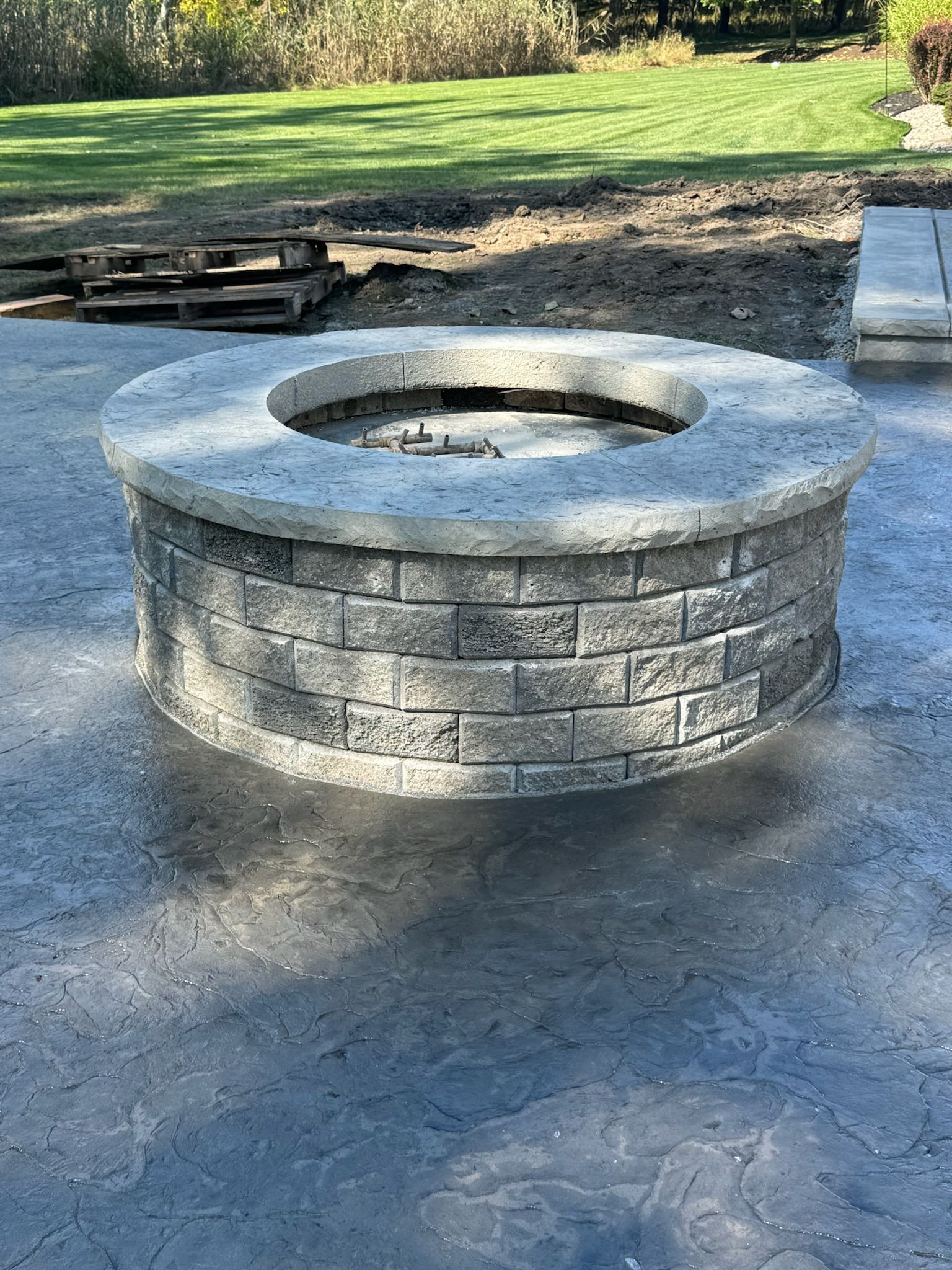A fire pit is sitting on top of a concrete patio.