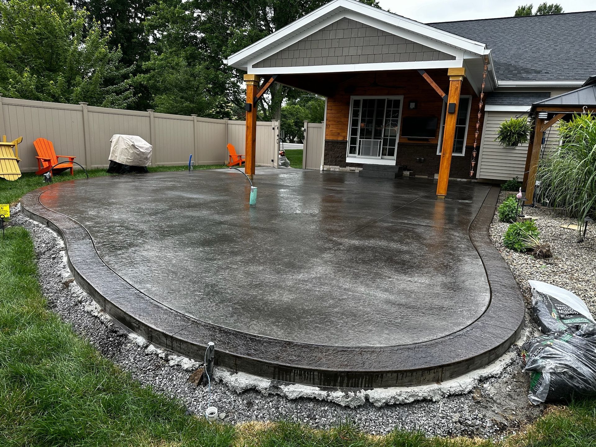A concrete patio is being built in front of a house.