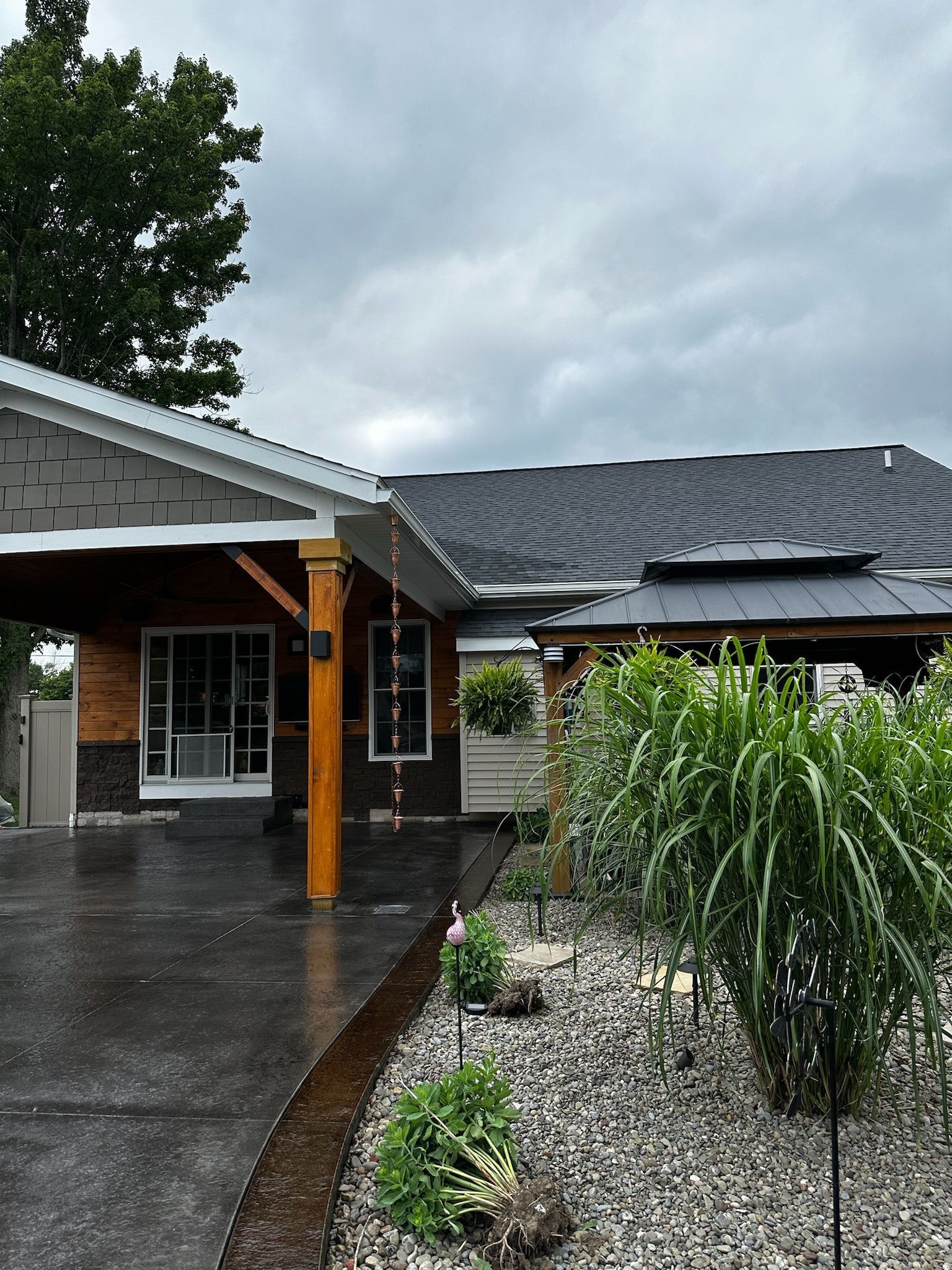 A house with a driveway and a covered porch on a cloudy day