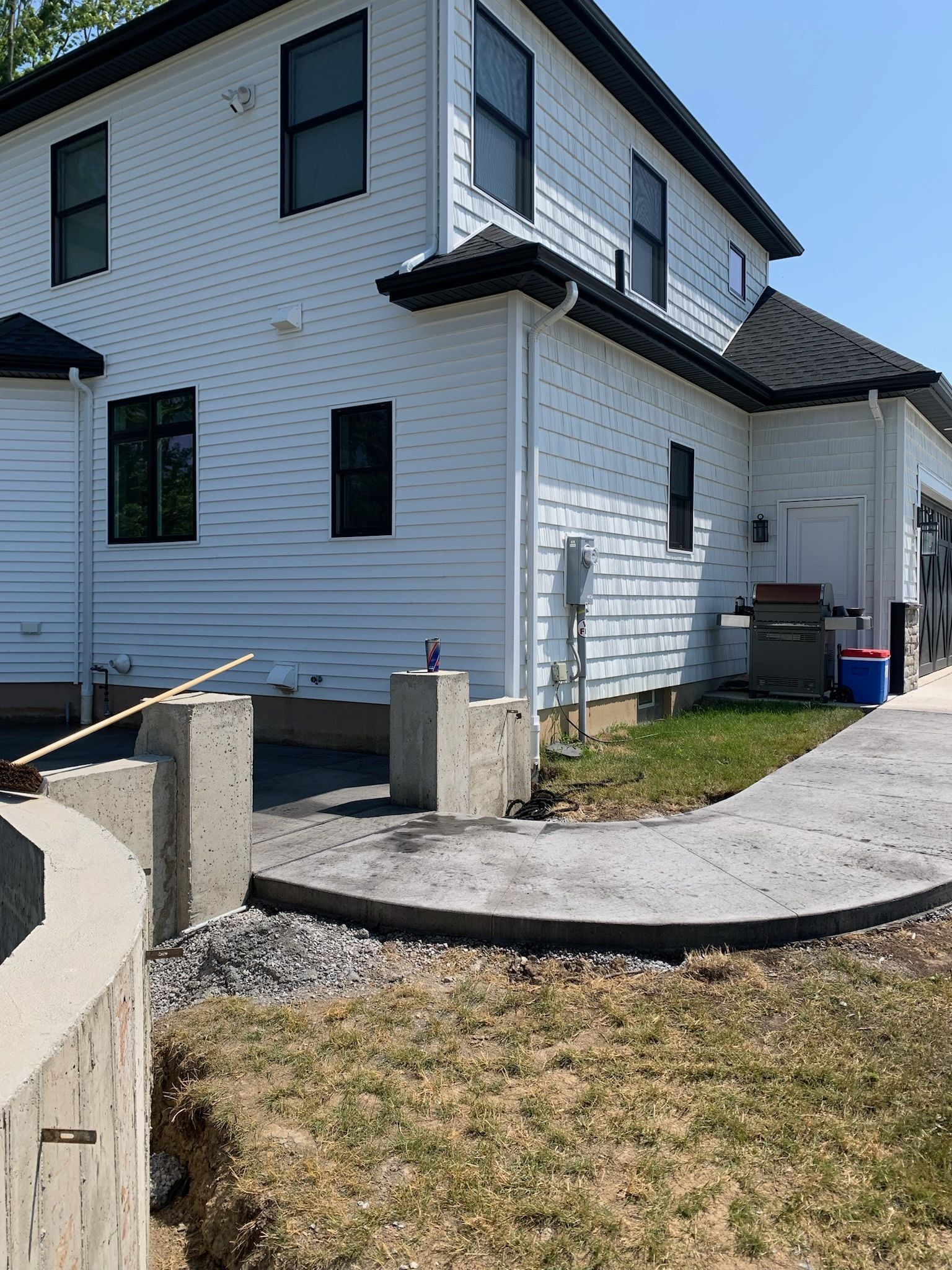 A white house with a concrete walkway in front of it.