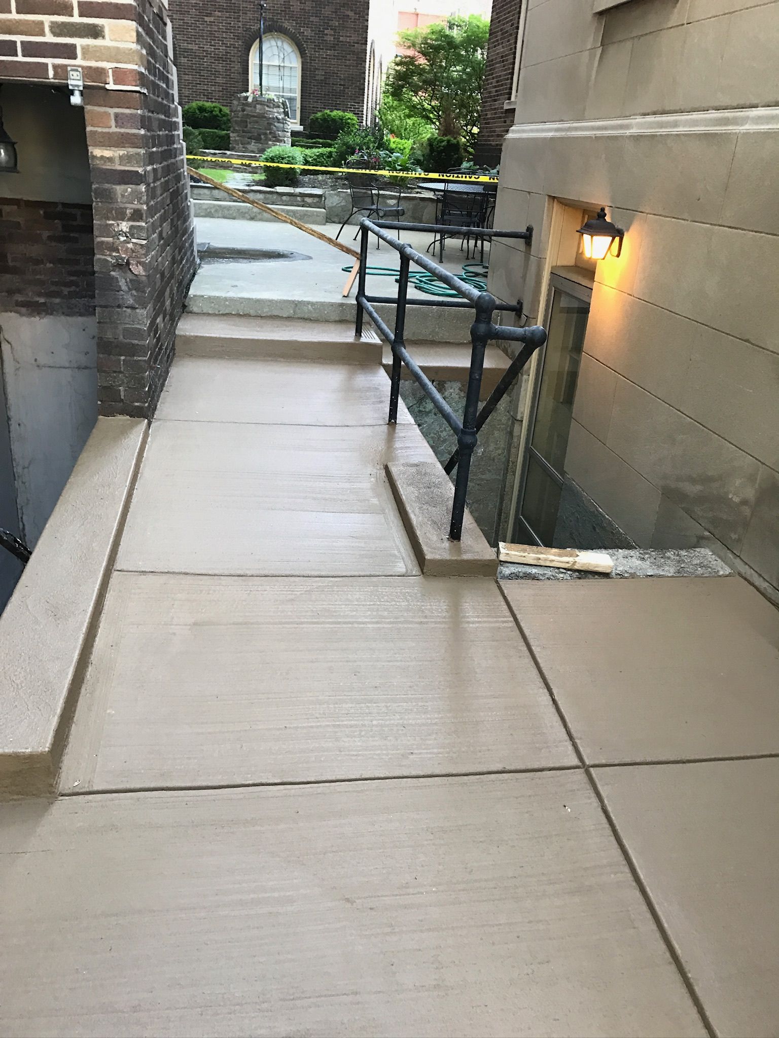 A concrete walkway with stairs leading up to a building.