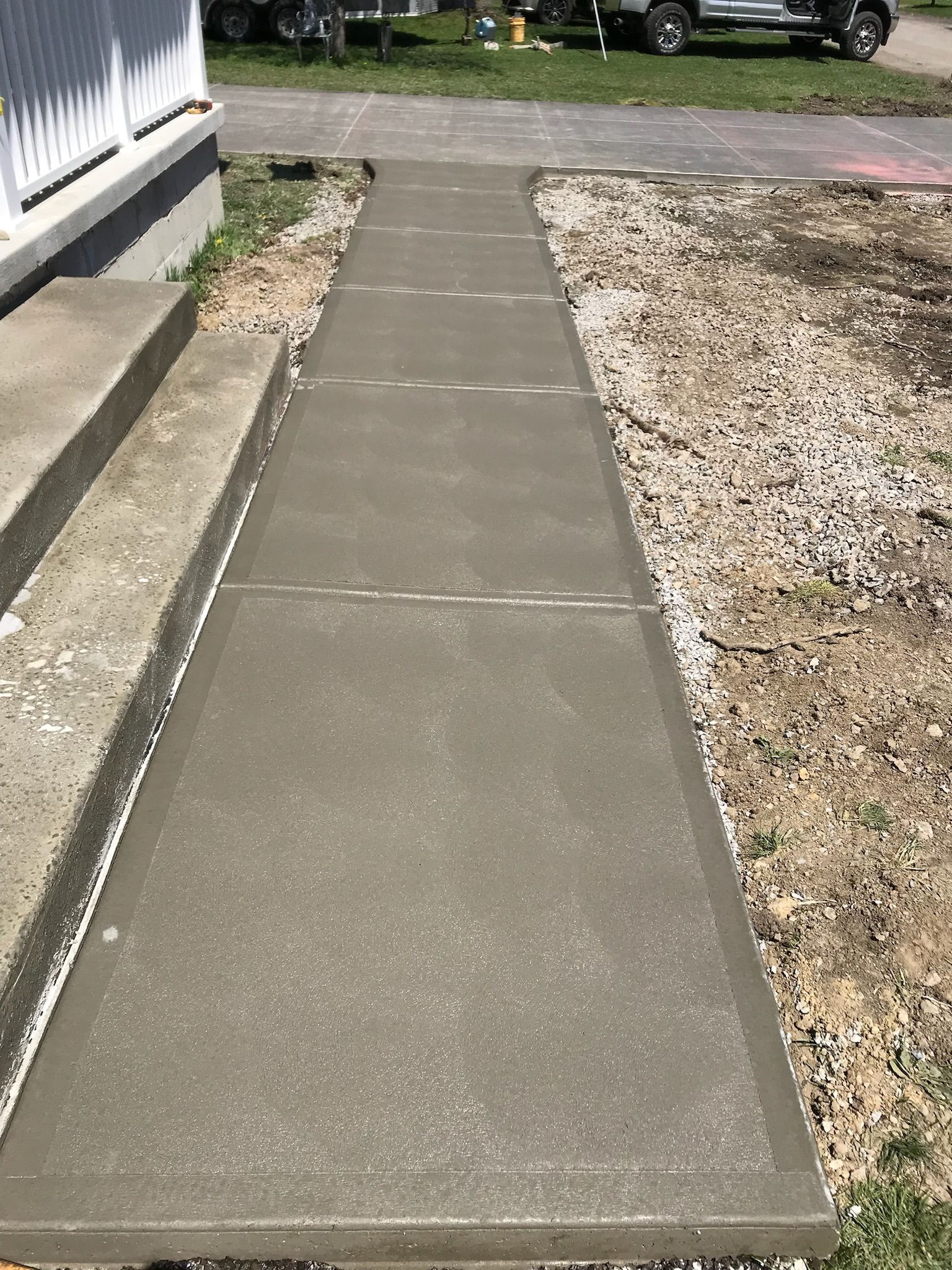 A concrete walkway is being built in front of a house.