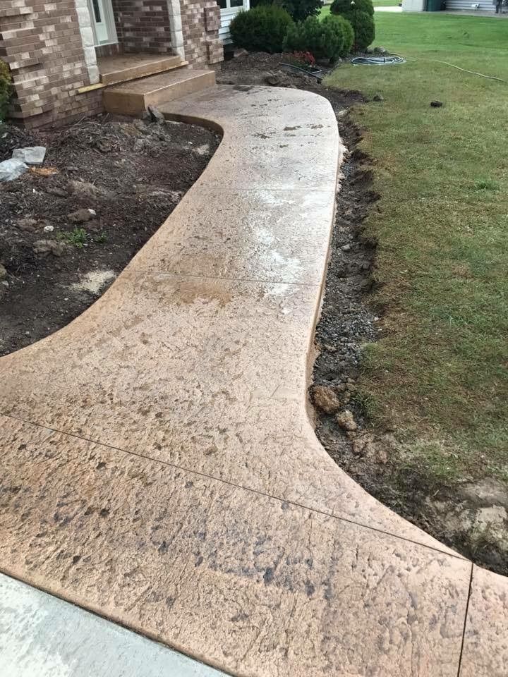 A concrete walkway is being built in front of a house.