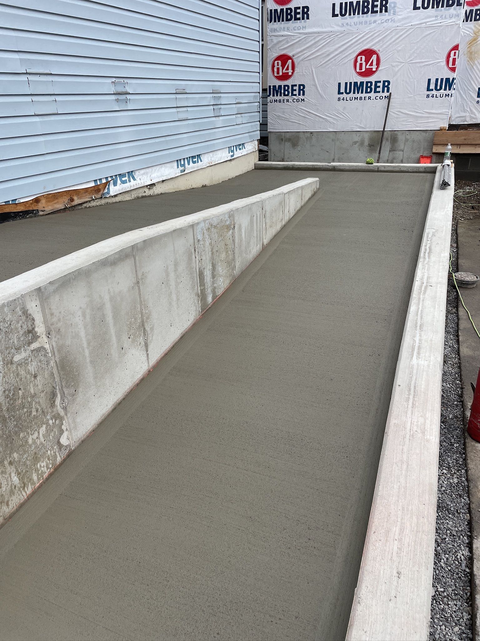 A concrete ramp is being built in front of a house.