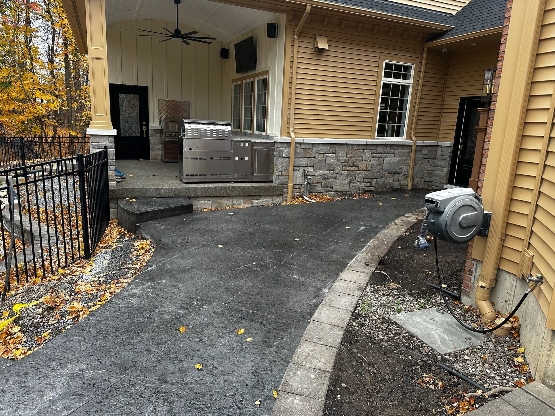 A driveway leading to a house with a hot tub in the backyard