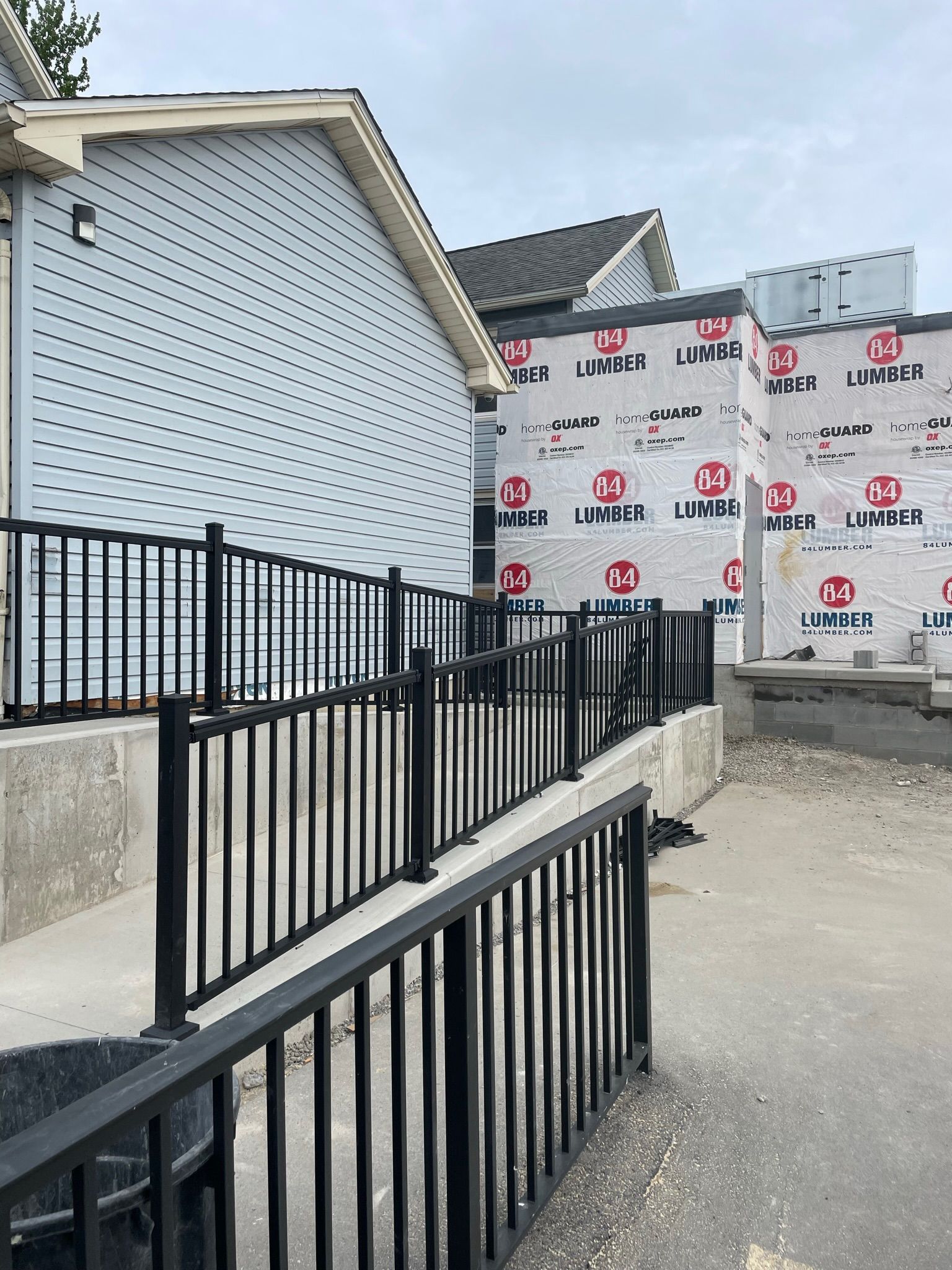 A house is being built with a ramp and a fence.
