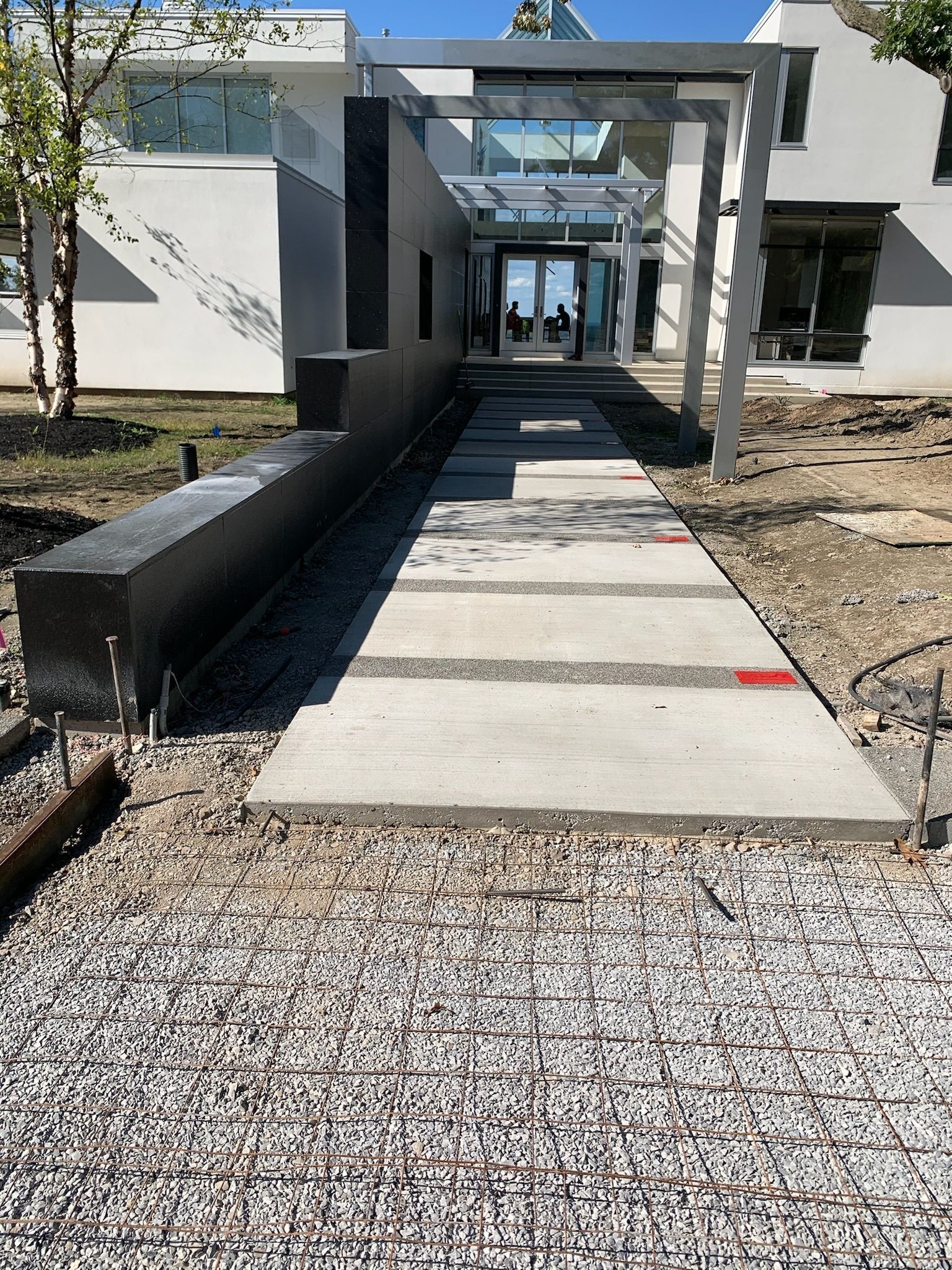 A concrete walkway leading to a large white building.