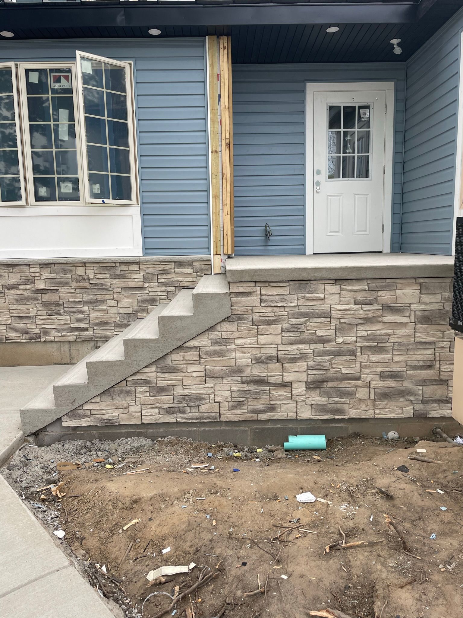 A blue house with a white door and stairs