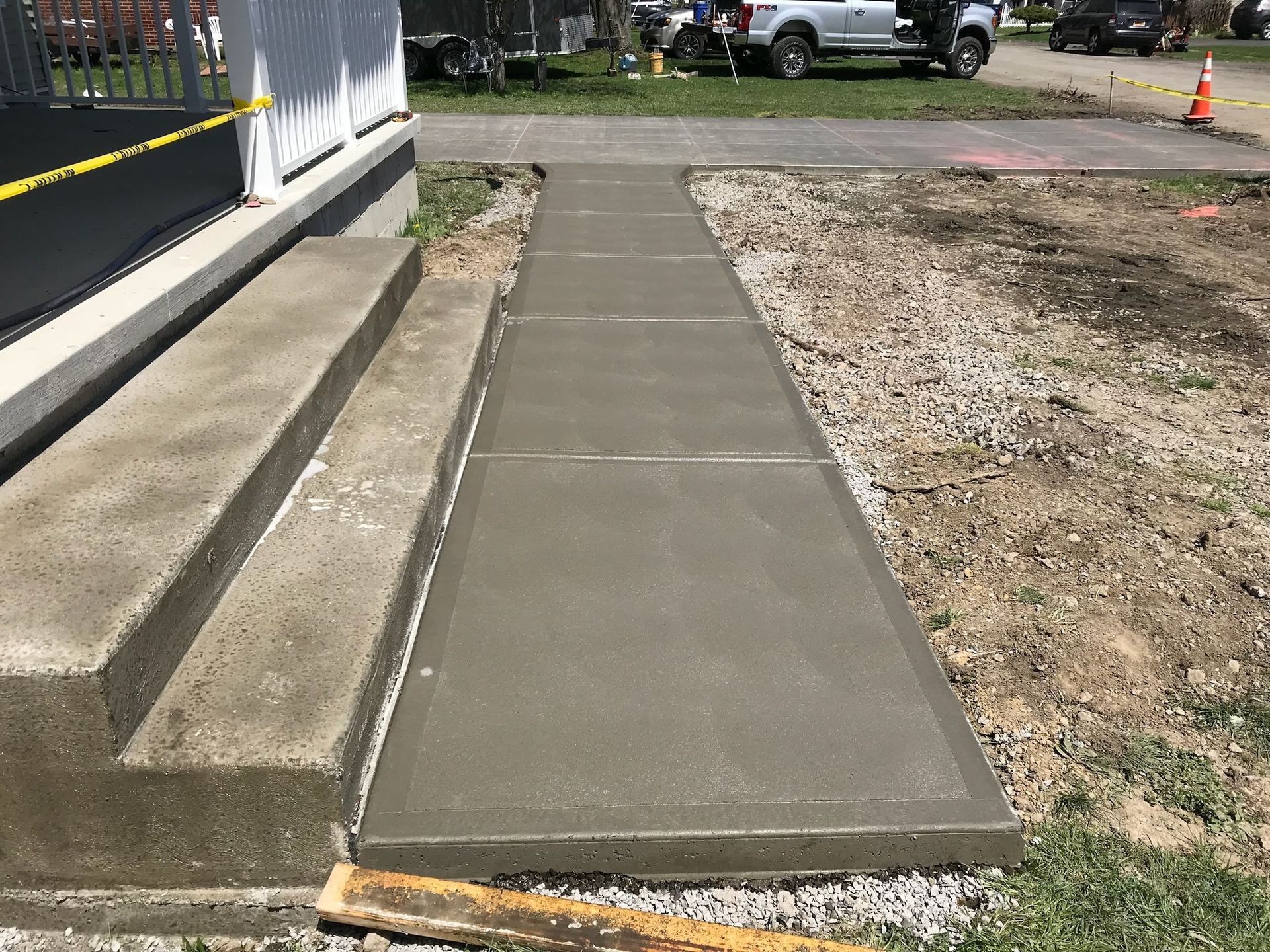 A concrete walkway is being built in front of a house.