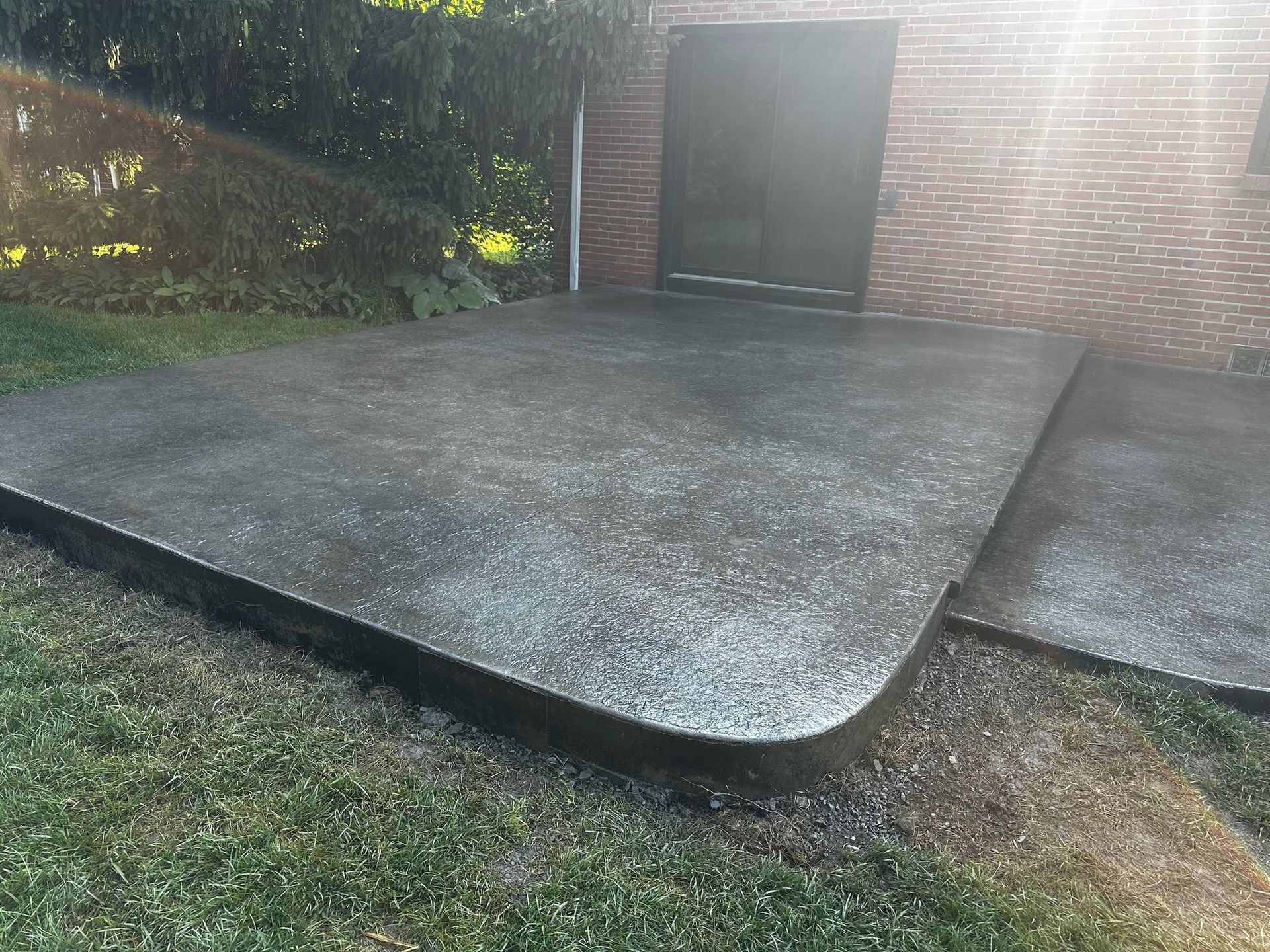 A brick building with a concrete patio in front of it.