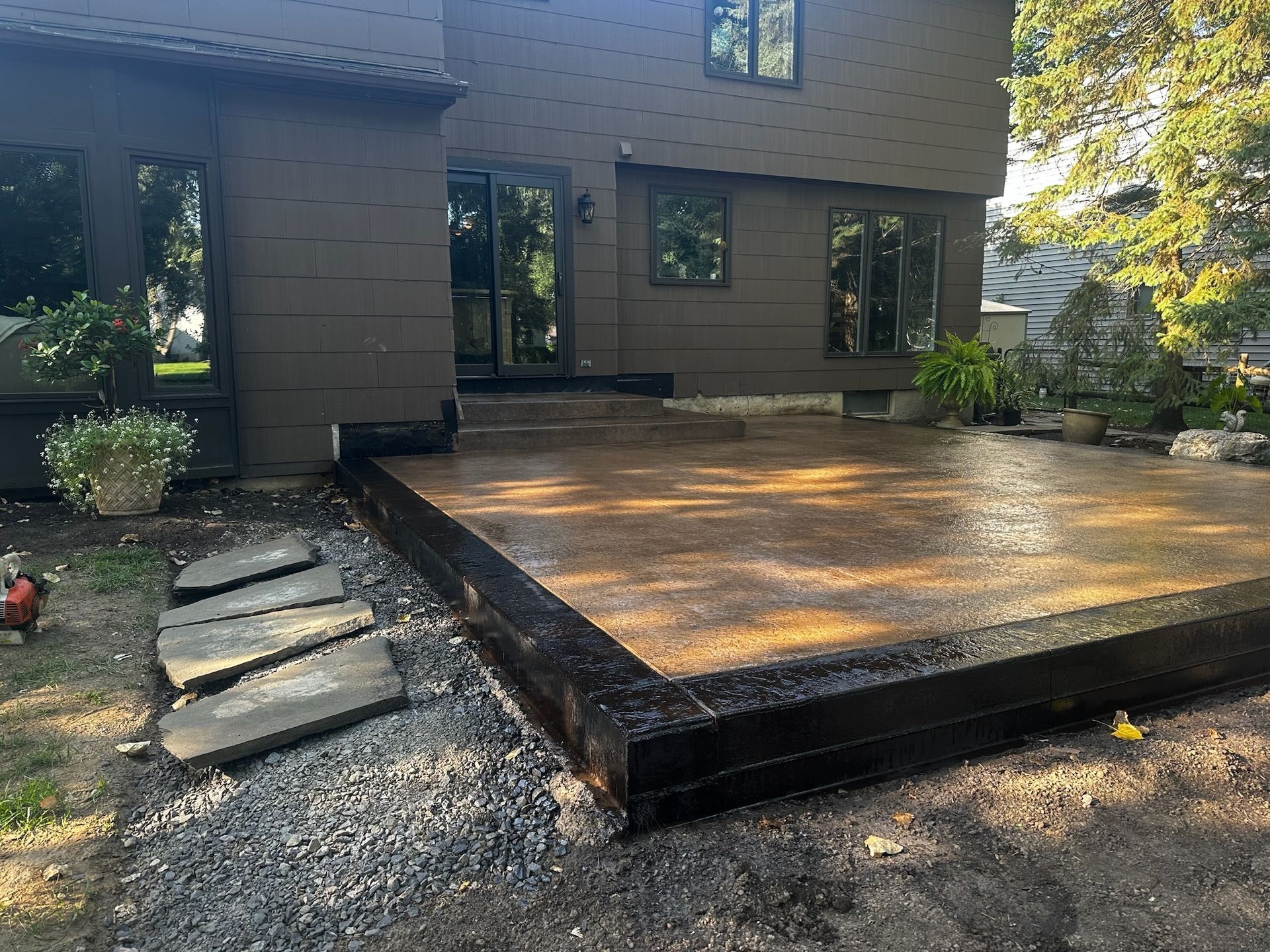 A concrete deck is being built in front of a house.