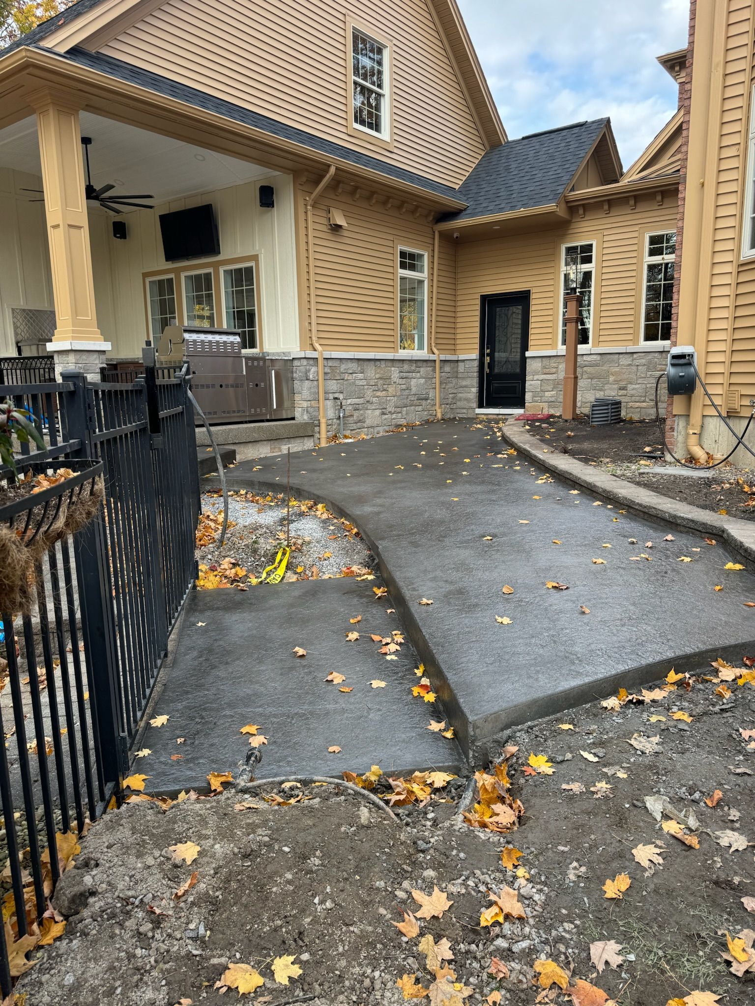 A large house with a concrete walkway leading to it.