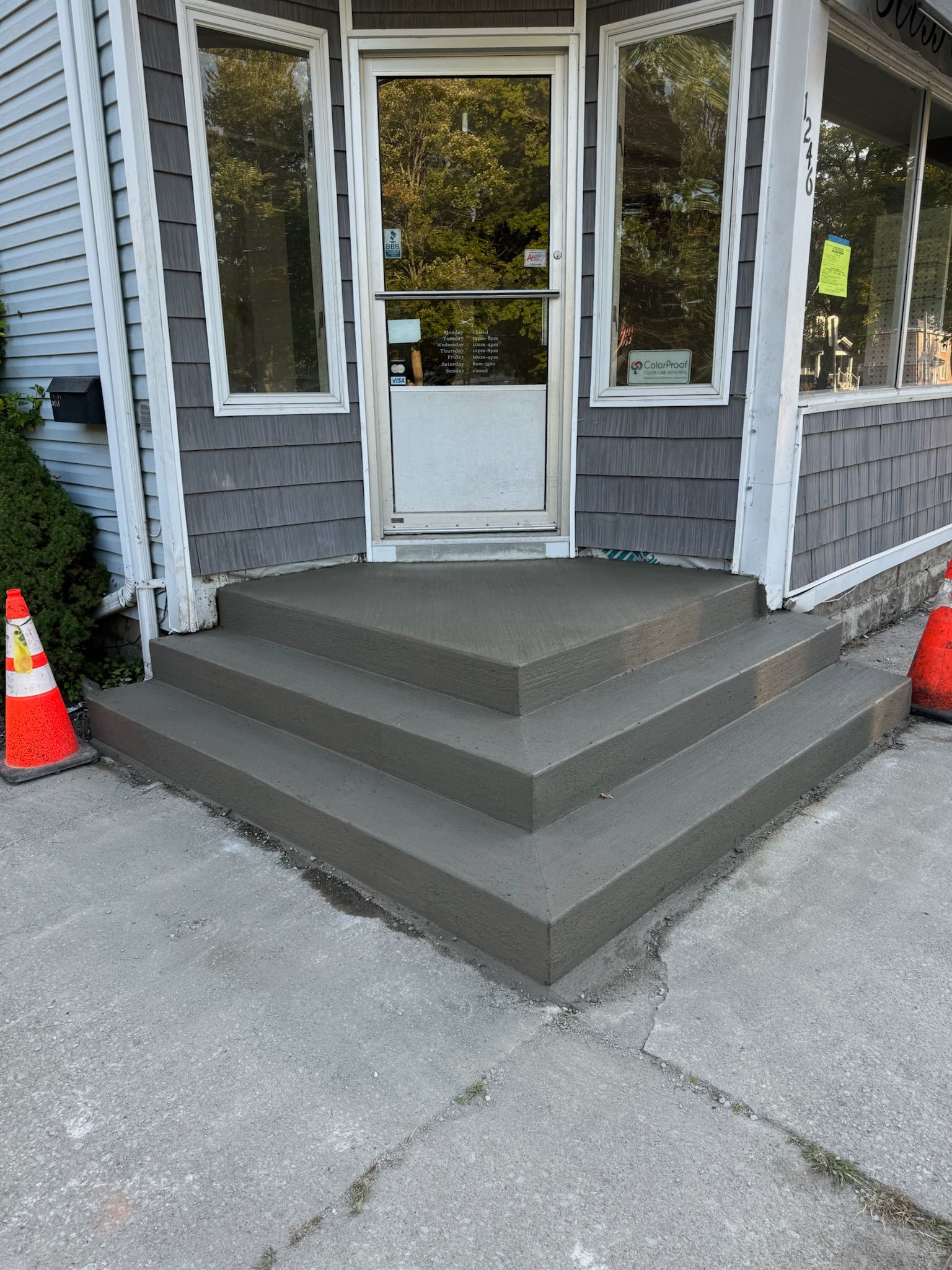 A concrete porch with steps leading to the front door of a building.