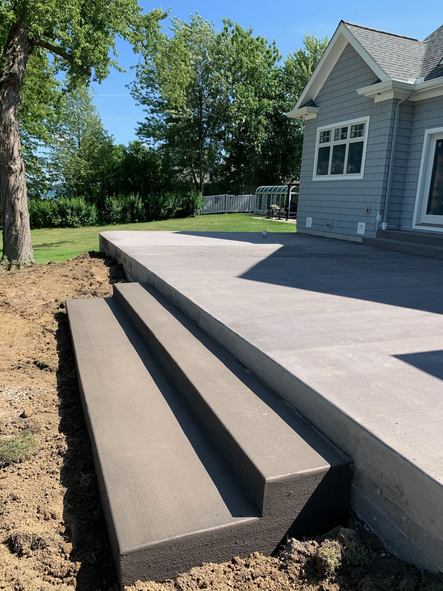 A concrete patio with stairs leading up to a house.
