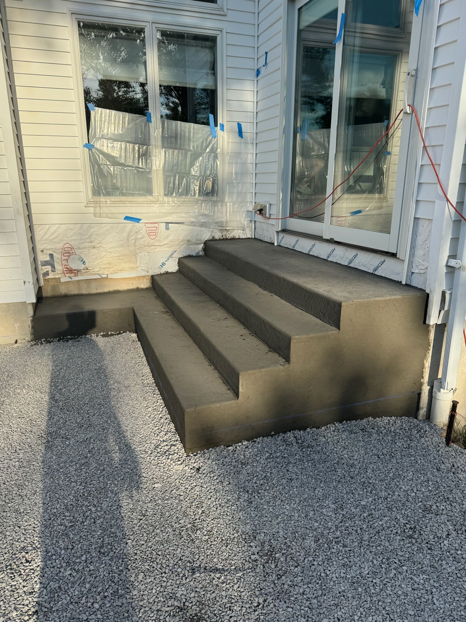 A concrete staircase is being built on the side of a house.