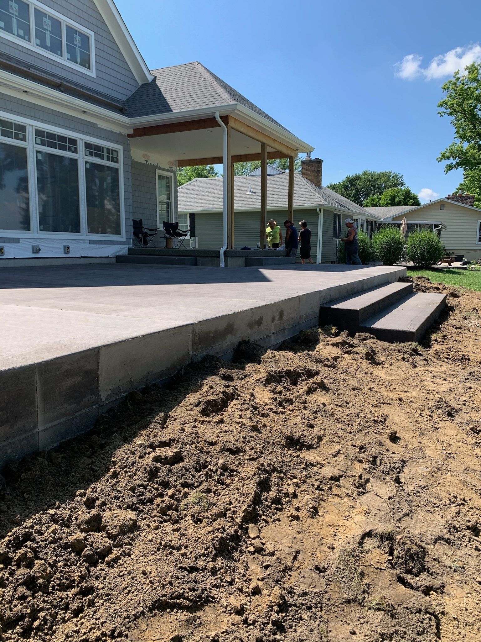 A large house with a patio and stairs in front of it.