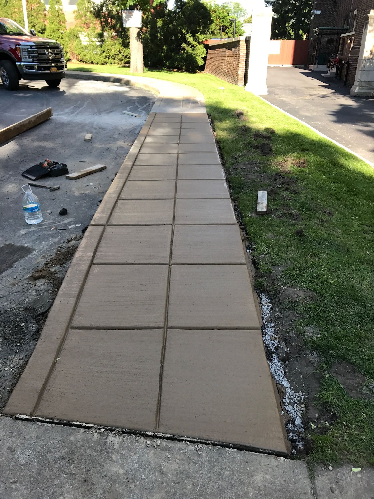 A concrete walkway is being built in front of a house.