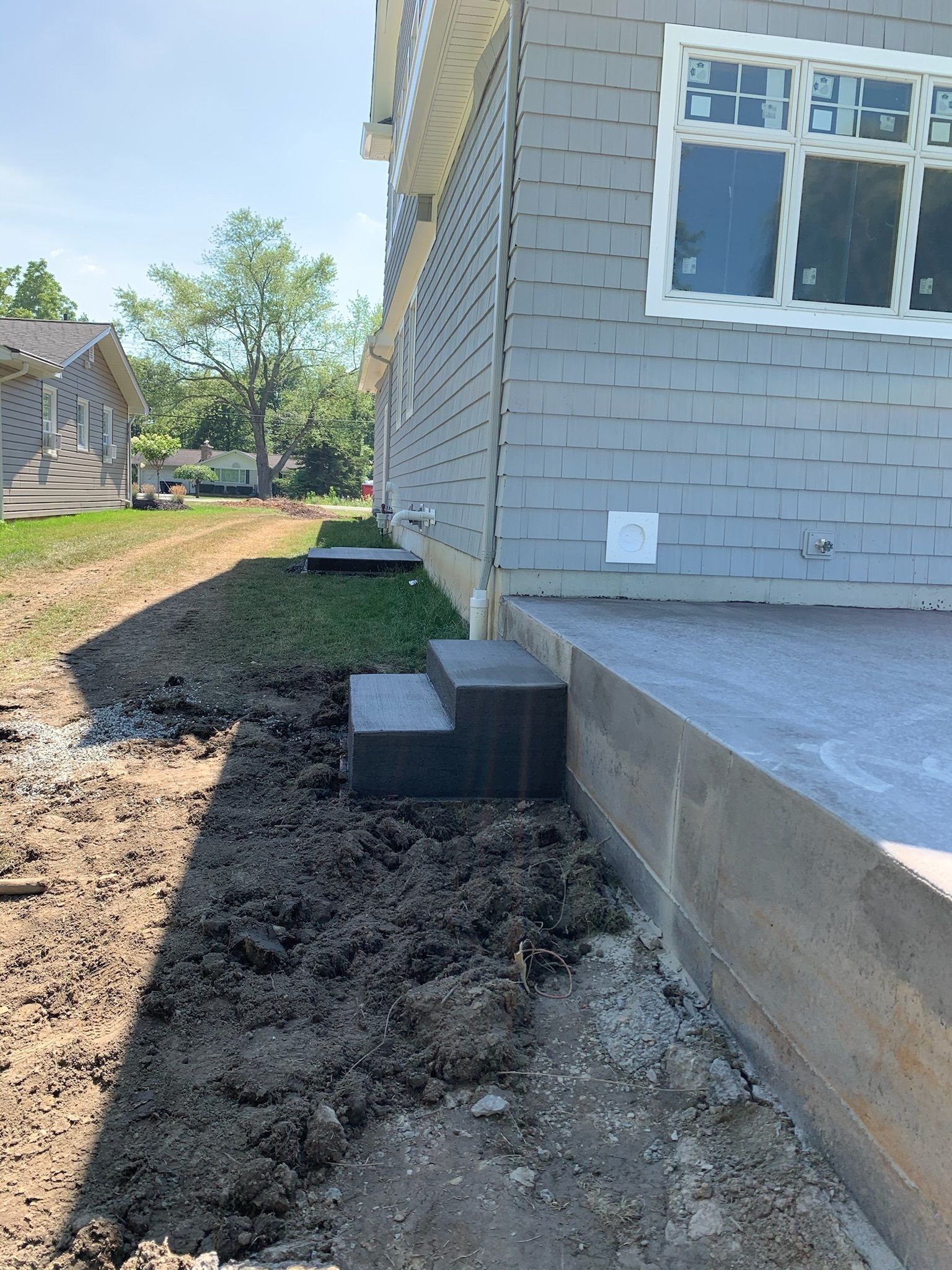 A house is being built with a lot of dirt in front of it.
