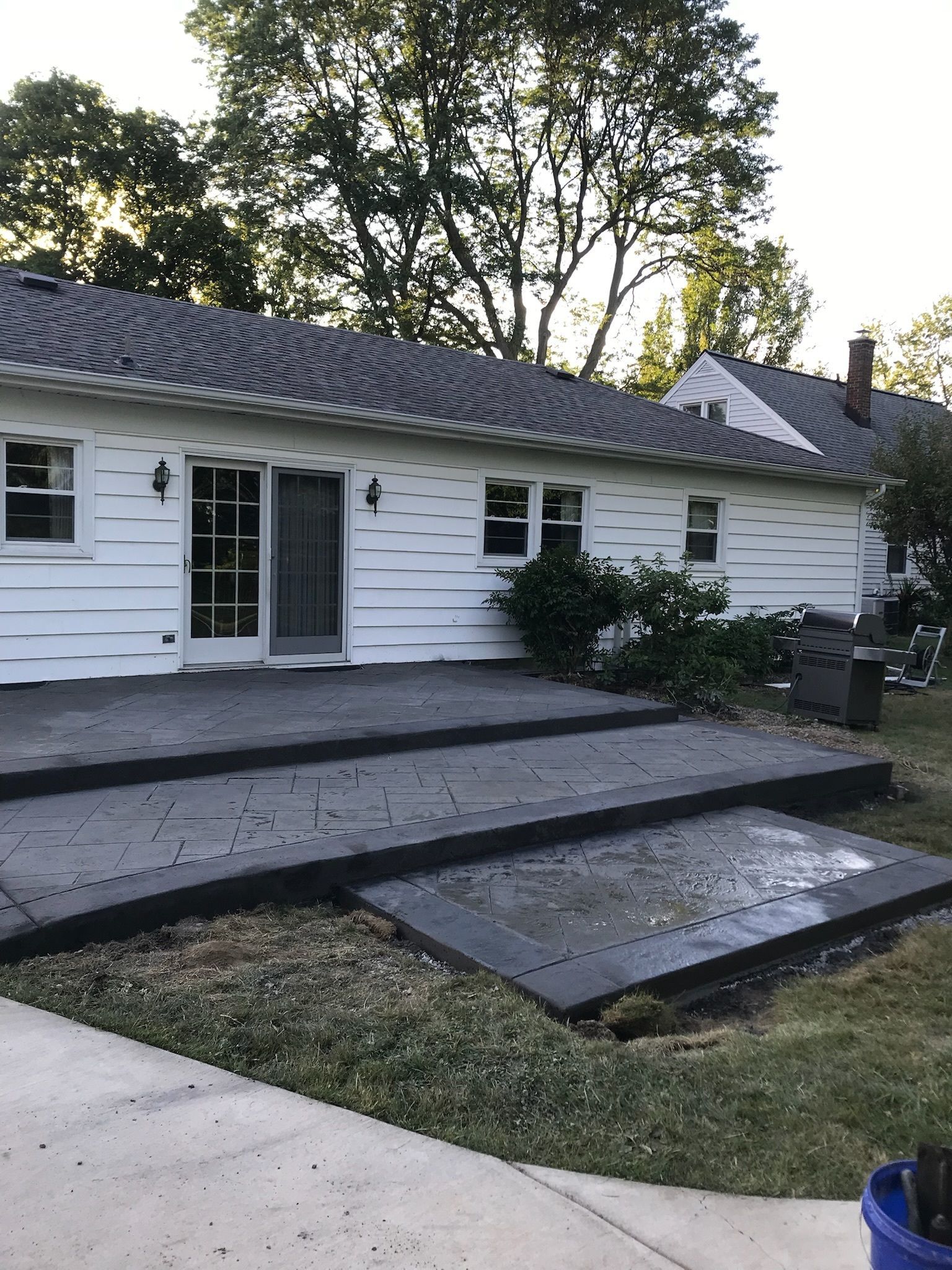 A white house with a concrete patio in front of it.