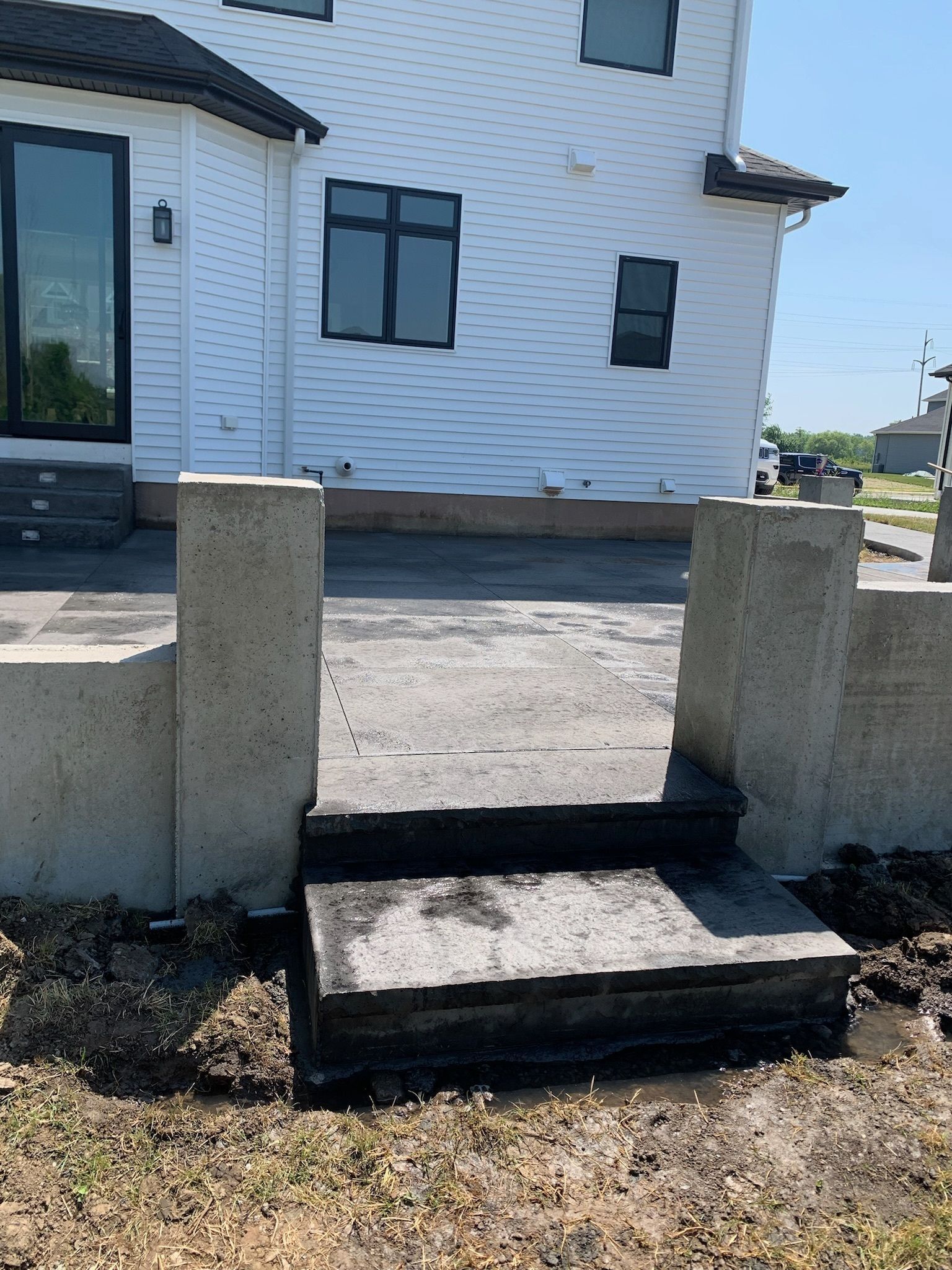 A white house with concrete steps leading up to it.