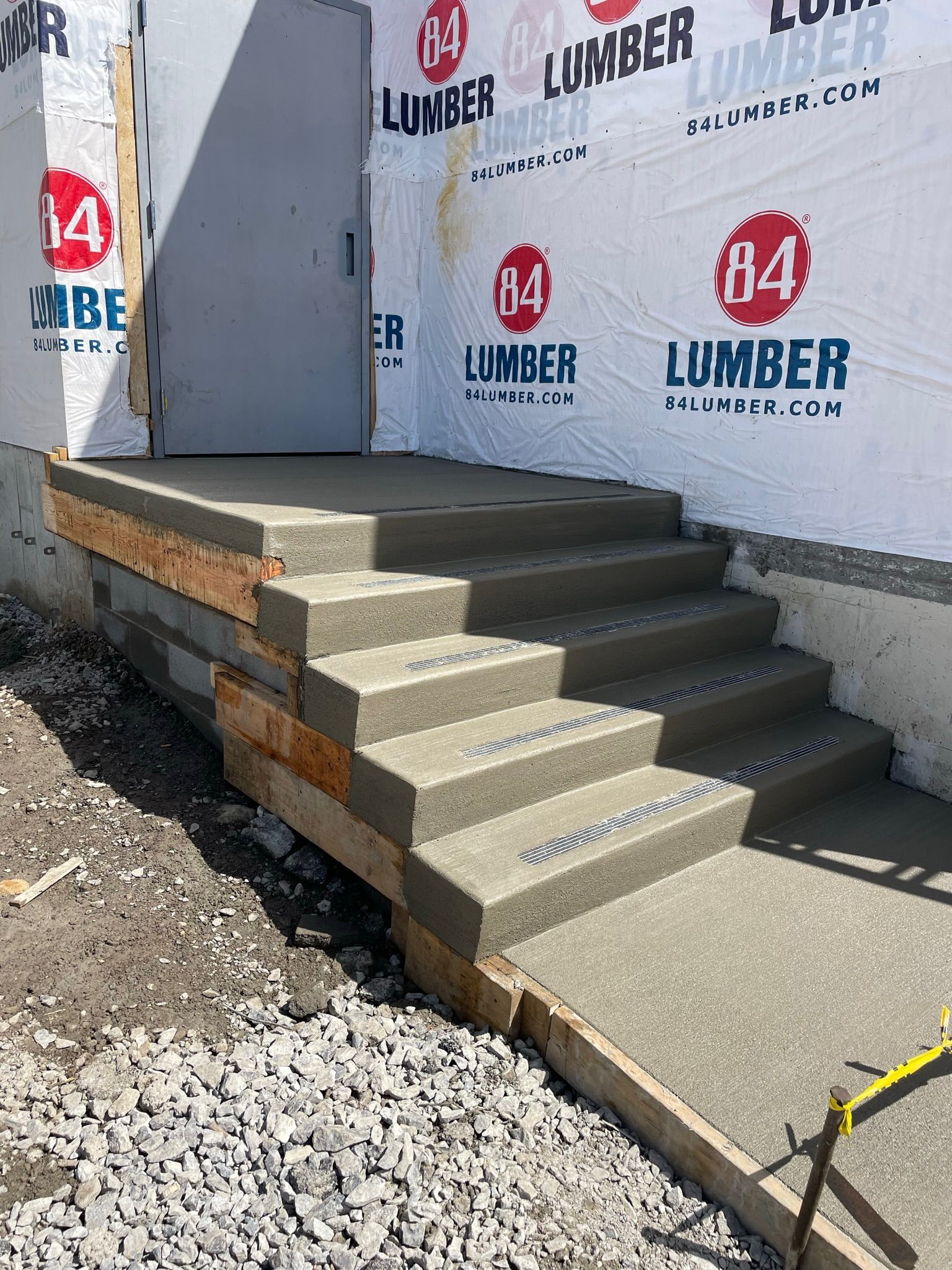 A set of concrete stairs being built in front of a building.