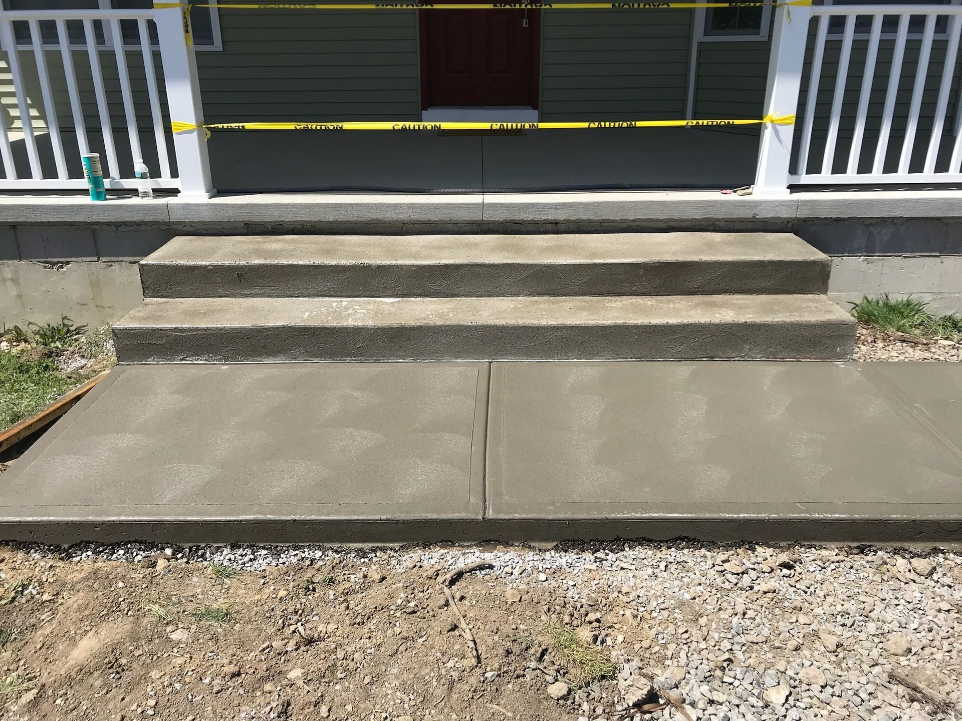 A concrete walkway is being built in front of a house.