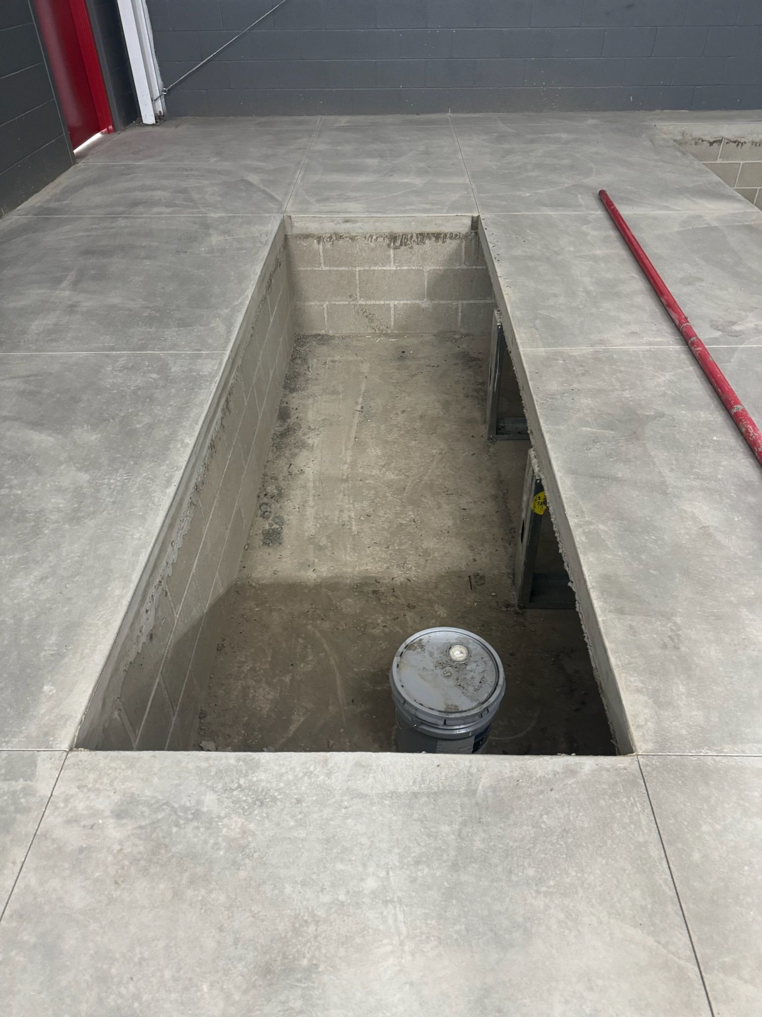 There is a hole in the floor with a bucket in it.